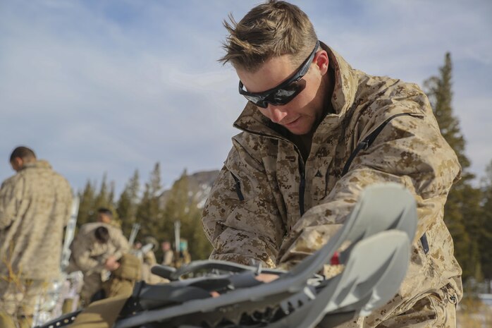 Lance Cpl. Justin Bunner, an engineer equipment operator with Combat Logistics Battalion 26, Headquarters Regiment, 2nd Marine Logistics Group, tightens his snow shoes onto his pack before a movement during a training exercise aboard U.S. Marine Corps Mountain Warfare Training Center at Bridgeport, California, Jan. 26, 2015. The Marines prepared their packs for “survival night,” where they would only have access to limited amounts of supplies to sustain themselves at their next bivouac site in the mountains. (U.S. Marine Corps photo by Lance Cpl. Kaitlyn Klein/Released)
