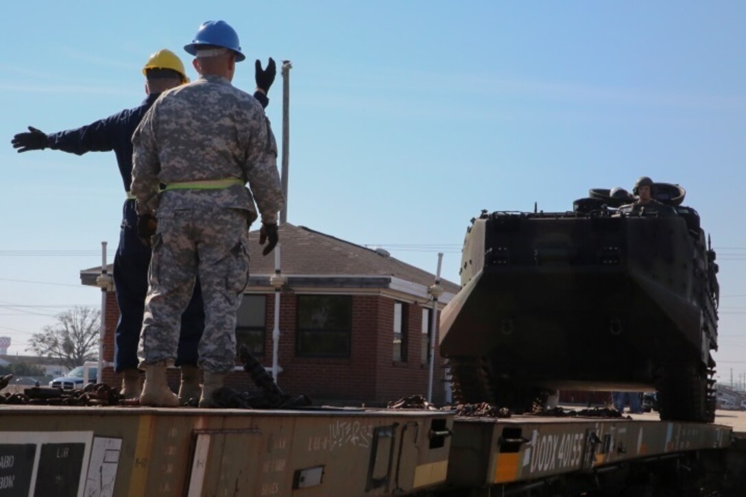 Army Sgt. 1st Class Grachya Kazanchyan, the rail noncommissioned officer in charge of Movement Control Company 171, observes a Marine with Combat Logistics Battalion 2 guide an amphibious assault vehicle onto a rail car during a railway operation training course aboard Marine Corps Base Camp Lejeune, N.C., Jan. 21, 2015. Marines from II Marine Expeditionary Force learned the skills necessary to load and unload vehicles and equipment to and from rail cars for transport during the course. (U.S. Marine Corps photo by Lance Cpl. Sullivan Laramie)