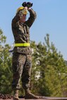 Corporal Justin Blanton, a landing support specialist with Headquarters Regiment, 2nd Marine Logistics Group, gives the hand and arm signal to stop while guiding a vehicle onto a rail car during a railway operation training course aboard Marine Corps Base Camp Lejeune, N.C., Jan. 21, 2015. In addition to beach and motor transportation operations, landing support specialists are tasked with conducting railway operations when the infrastructure allows. (U.S. Marine Corps photo by Lance Cpl. Sullivan Laramie)