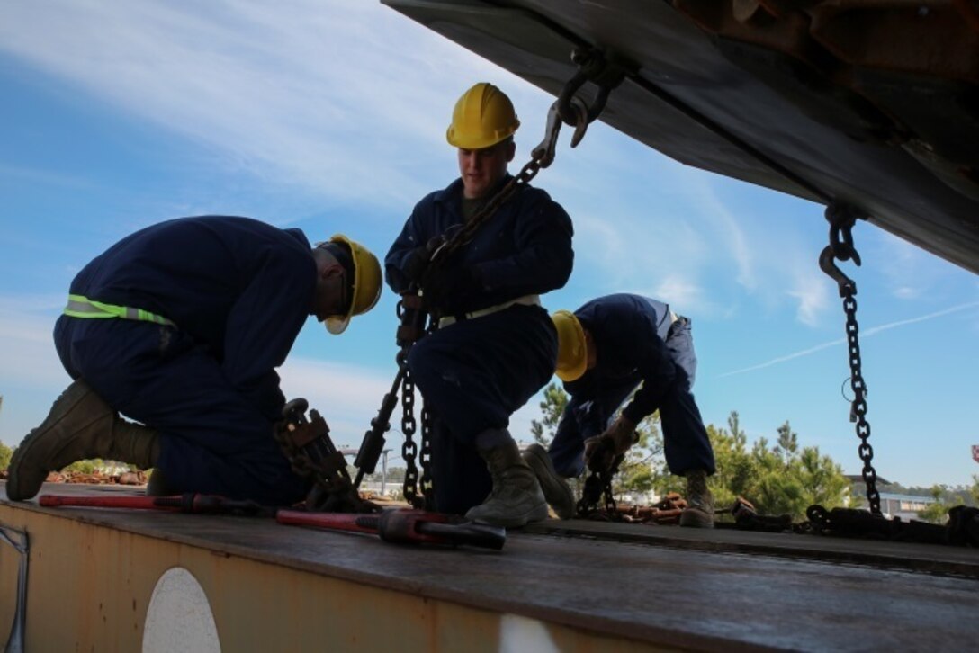 Marines with Combat Logistics Battalion 2 secure an amphibious assault vehicle to a rail car during a railway operation training course aboard Marine Corps Base Camp Lejeune, N.C., Jan. 21, 2015. During railway operations, each vehicle, piece of equipment and cargo container must be placed and chained to a predetermined part of the rail car to avoid damage caused by movement. (U.S. Marine Corps photo by Lance Cpl. Sullivan Laramie)