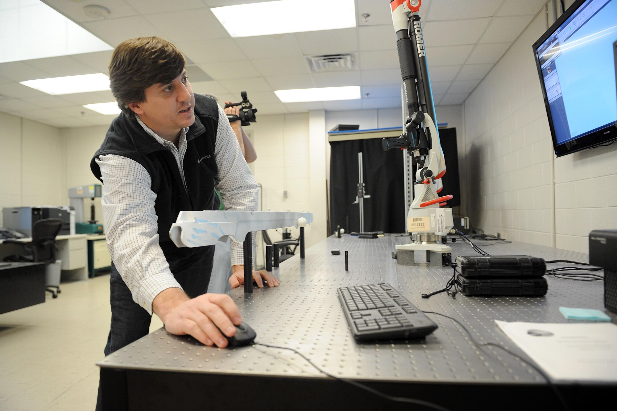 Tracy Rycroft uses a laser scanner to capture part dimensions used to construct a 3-D model. After programming, the printer can run on its own 24 hours a day without manning. Rycroft is a 573rd Commodities Maintenance Squadron mechanical engineering technician. (U.S. Air Force photo/Tommie Horton)