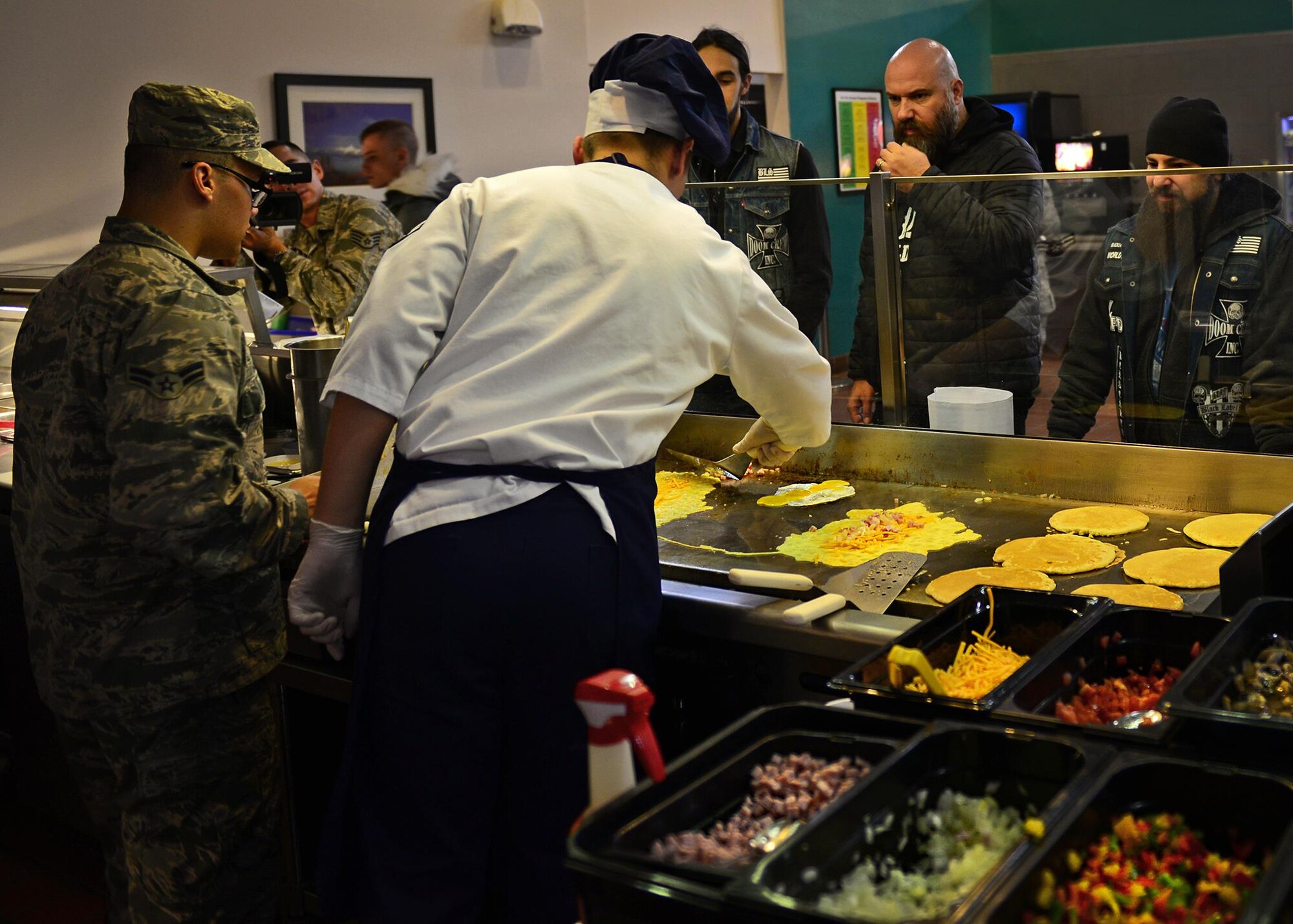 U.S. Air Force Air Commandos with the 27th Special Operations Force Support Squadron prepare breakfast for the Black Label Society in the Pecos Trail Dining Facility Jan. 28, 2015 at Cannon Air Force Base, N.M. The band was provided a tour of Cannon as part of a United Services Organization concert performed later that evening. (U.S. Air Force photo/Airman 1st Class Shelby Kay-Fantozzi) 