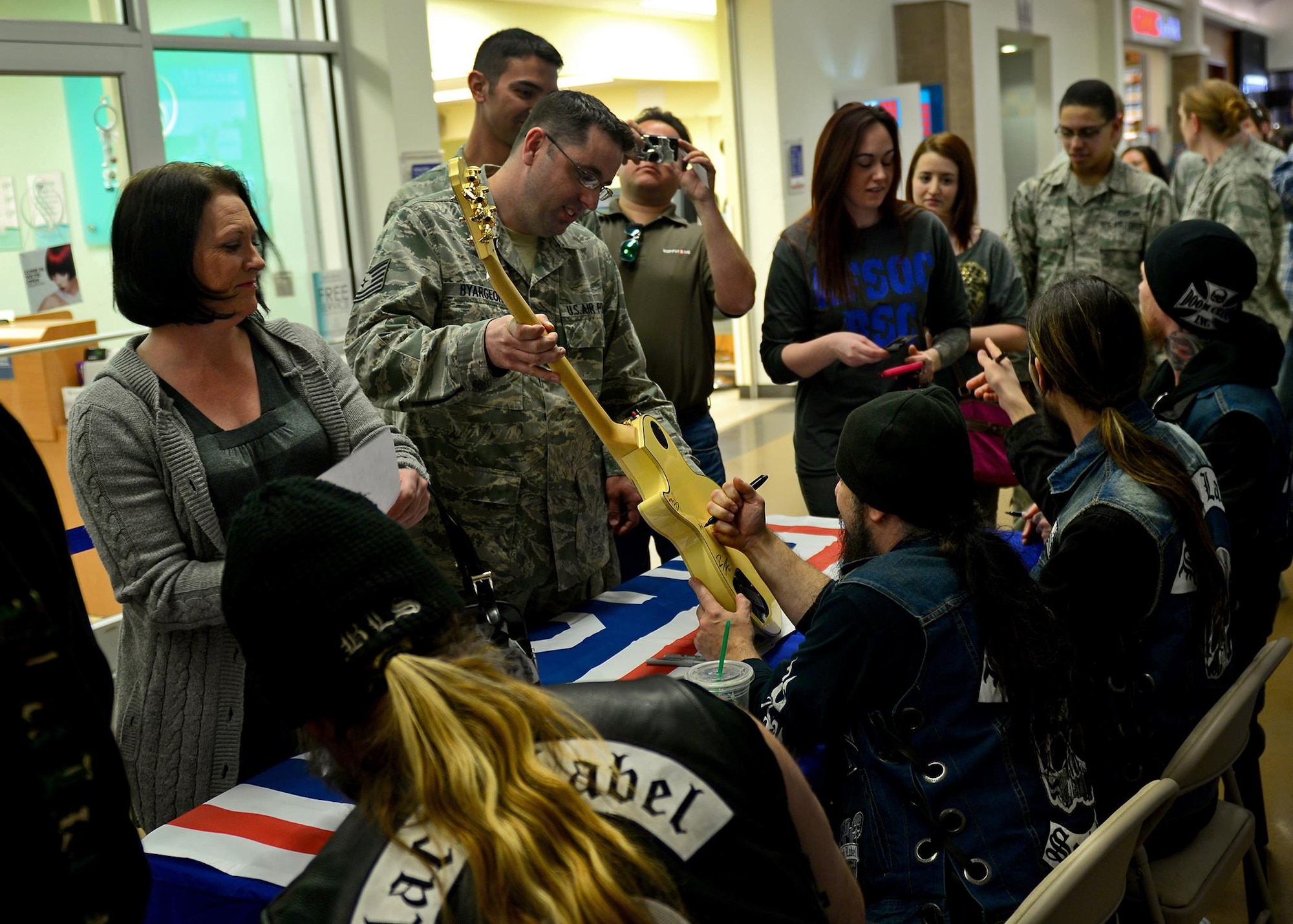 U.S. Air Force Air Commandos and family members line the main hall of the Base Exchange to meet and greet with the Black Label Society Jan. 28, 2015 at Cannon Air Force Base, N.M. The band gathered for signings and photographs with fans and enthusiasts from the base as part of their pre-concert tour. (U.S. Air Force photo/Airman 1st Class Shelby Kay-Fantozzi) 