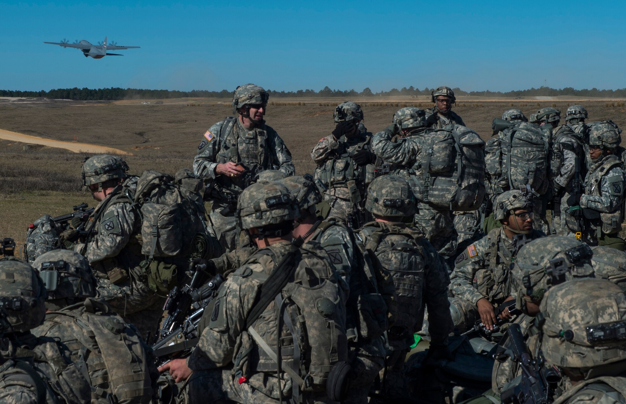 Members of the U.S. Army 1st Brigade 10th Mountain Division stationed at Fort Drum, N.Y., conduct training as a C-130 Hercules takes off during an exercise at a the Joint Readiness Training Center at Fort Polk, La., Jan. 18, 2015. JRTC is a 34th Combat Training Squadron exercise for the U.S. Army that improves unit readiness by providing realistic, stressful, joint and combined arms training across the full spectrum of conflict.  (U.S. Air Force photo/Staff Sgt. Gustavo Gonzalez/RELEASED)
