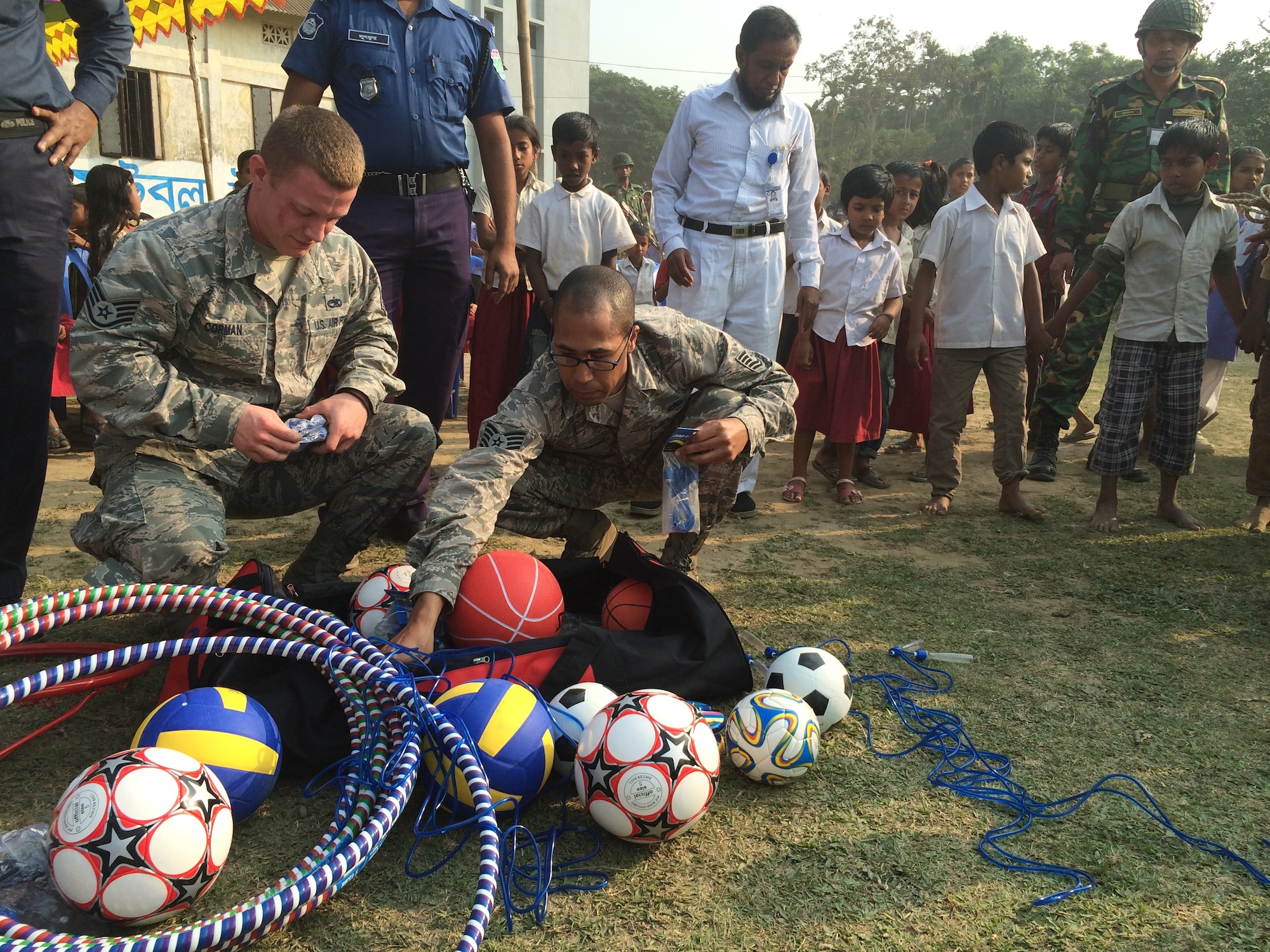 U.S. Air Force Staff Sergeant Tony Corman (left) and Tech. Sgt. Dario Jusino-Rodriguez prepare to distribute sporting goods to students at Goainghat Primary School in Sylhet, Bangladesh during Exercise COPE SOUTH, Jan. 28, 2015. Corman is assigned to the 374th Maintenance Squadron and Rodriguez is a assigned to the 374th Aircraft Maintenance Squadron, Yokota Air Base, Japan. COPE SOUTH helps cultivate common bonds, foster goodwill, and improve readiness and compatibility between members of the Bangladesh and U.S. Air Forces. (U.S. Air Force photo by Senior Airman Ashley Powell/Released)