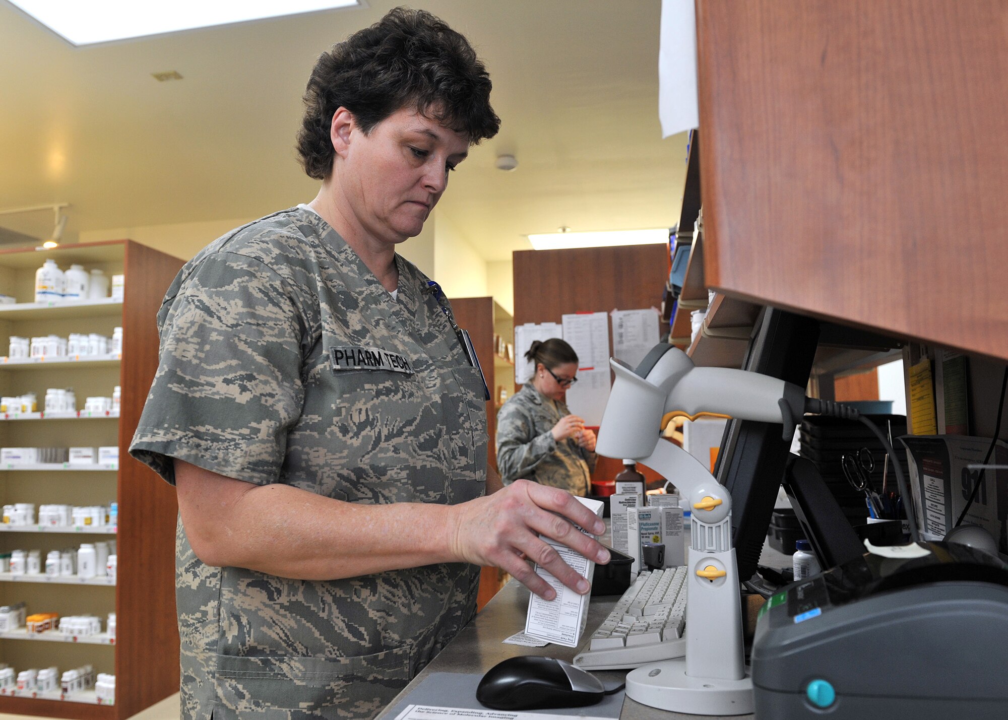 Jeanne Wilson, 341st Medical Support Squadron pharmacy technician, scans medications Jan. 27 at the Malmstrom Air Force Base, Mont., pharmacy. Wilson also oversees the pharmacy’s home defense package, a stock of medications that is stored for contingencies, and is the pharmacy’s area control monitor. (U.S. Air Force photo/John Turner)