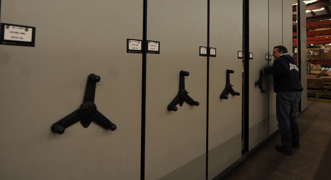 Pete Morton, 7th Logistic Readiness Squadron B-1 Aircraft Parts Store materiel handler, opens a track-riding shelving unit Jan. 8, 2015, at Dyess Air Force Base, Texas. Multiple shelving units were holding parts that are being transitioned to the main warehouse. Morton helped maintain accountability for more than 116,000 parts during the move. This will help streamline the parts ordering and pick up process for flightline B-1 maintainers. (U.S. Air Force photo by Airman 1st Class Alexander Guerrero/Released)