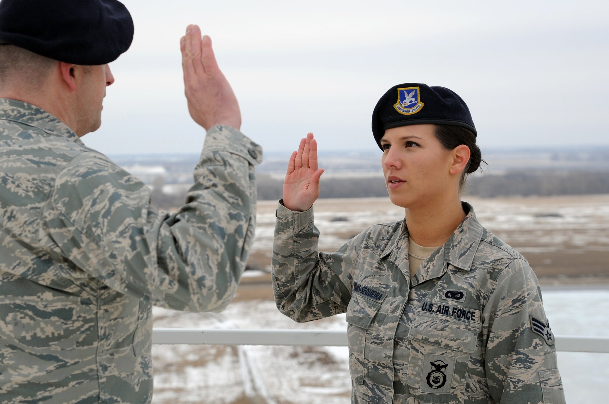 Senior Airman Ninoska Williams-Sequiera, 319th Security Forces Squadron commander's support staff, is administered the Oath of Enlistment by 319th SFS Commander Lt. Col. Jeffery Becker on Cavalier Air Force Station, N.D., January 30, 2014. Williams-Sequiera reenlisted in the U.S. Air Force from atop the Precision Acquisition Radar building, and is among the few Airman to do so. (U.S. Air Force photo/Staff Sgt. David Dobrydney)
