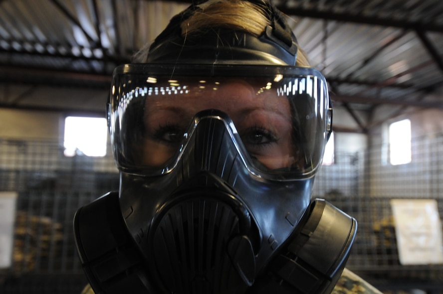 Oregon Air National Guard Senior Airman Shasta Petersen, 173rd Fighter Wing Logistics Readiness Squadron, demonstrates how to use the M-50 Joint Service General Purpose Mask at Kingsley Field, Ore. Jan. 28, 2015. The M-50 mask provides the user with a larger field of view and less breathing resistance as compared to previous MCU-2/P Protective Mask. (U.S. Air National Guard photo by Tech. Sgt. Daniel J. Condit/Released)