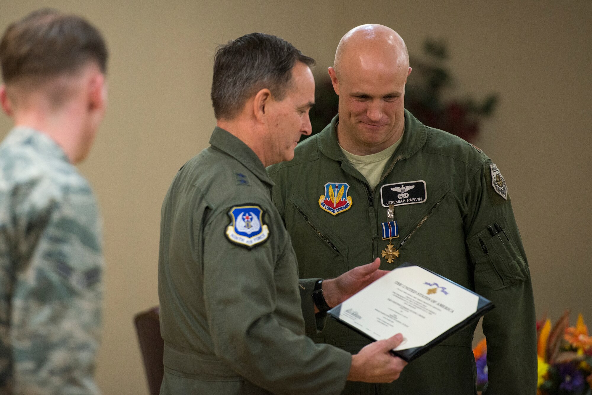 U.S. Air Force Maj. Jeremiah Parvin, 75th Fighter Squadron A-10C Thunderbolt II pilot, smiles as Maj. Gen H.D. Polumbo Jr., Ninth Air Force commander, presents a certificate during a Distinguished Flying Cross presentation ceremony Jan. 29, 2015, at Moody Air Force Base, Ga. Parvin earned the Distinguished Flying Cross with Valor for his actions in Afghanistan in 2008 and is credited with saving the lives of six Marines. (U.S. Air Force photo by Senior Airman Ryan Callaghan/Released)