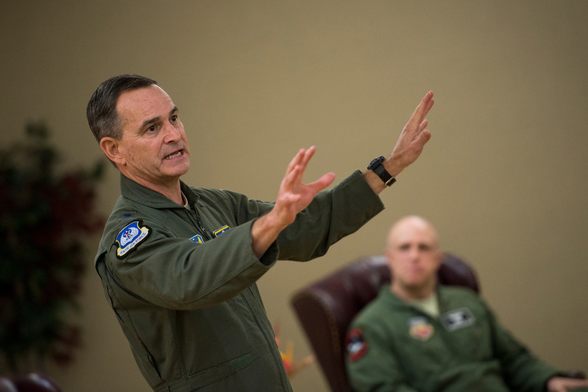 U.S. Air Force Maj. Gen. H.D. Polumbo Jr., Ninth Air Force commander, recounts the actions of Maj. Jeremiah Parvin, seated, 75th Fighter Squadron A-10C Thunderbolt II pilot, during a Distinguished Flying Cross presentation ceremony Jan. 29, 2015, at Moody Air Force Base, Ga. While flying in Afghanistan in 2008, Parvin received a call for help and flew 320 miles through adverse weather to the aid of a Marine Special Operations Team.  (U.S. Air Force photo by Senior Airman Ryan Callaghan/Released)
