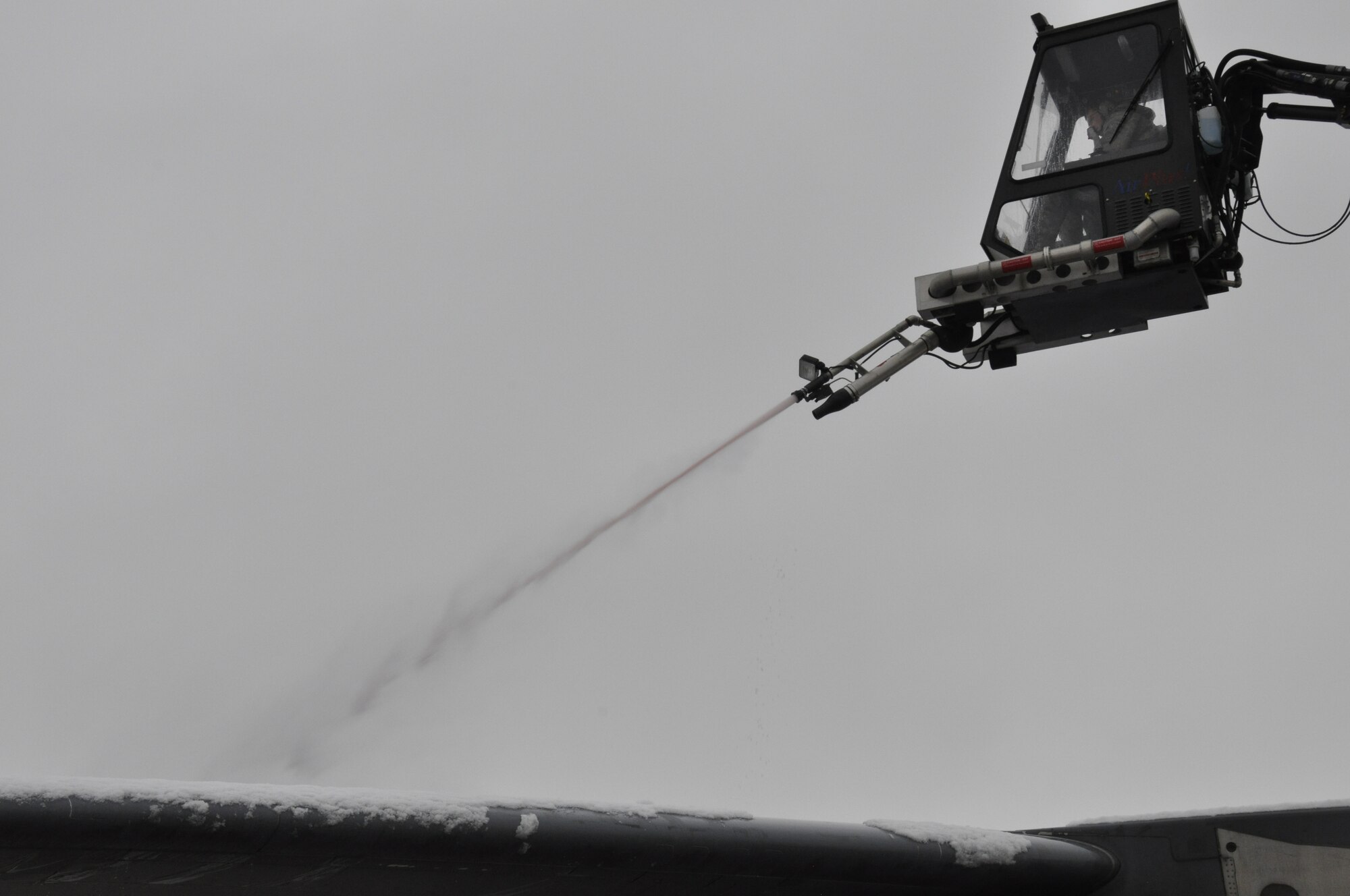A 514th Air Mobility Wing Airman de-ices the wing of a C-17 Globemaster, Jan. 24, after a winter storm hit the area. (Air Force photo/Master Sgt. Donna T. Jeffries)