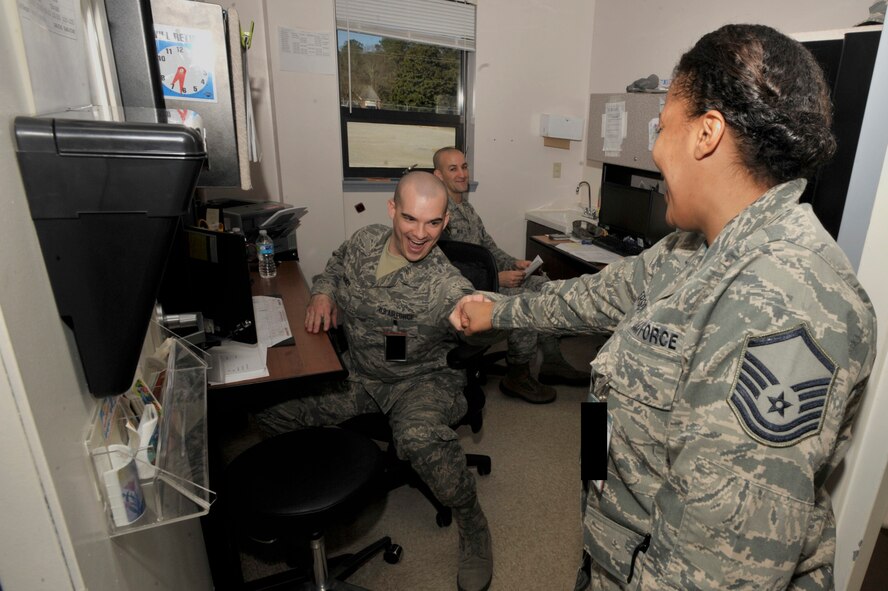 U.S. Air Force Senior Airman Benjamin Starkey, 20th Medical Operations Squadron medical technician, shares a ‘fist bump’ with Master Sgt. Taliah Wilkerson, 20th MDOS medical services flight chief, in the pediatrics clinic at Shaw Air Force Base, S.C., Jan. 30, 2015. The medical services flight includes three sections: ambulance services, immunizations, and pediatrics. (U.S. Air Force photo by Airman 1st Class Jonathan Bass/Released)