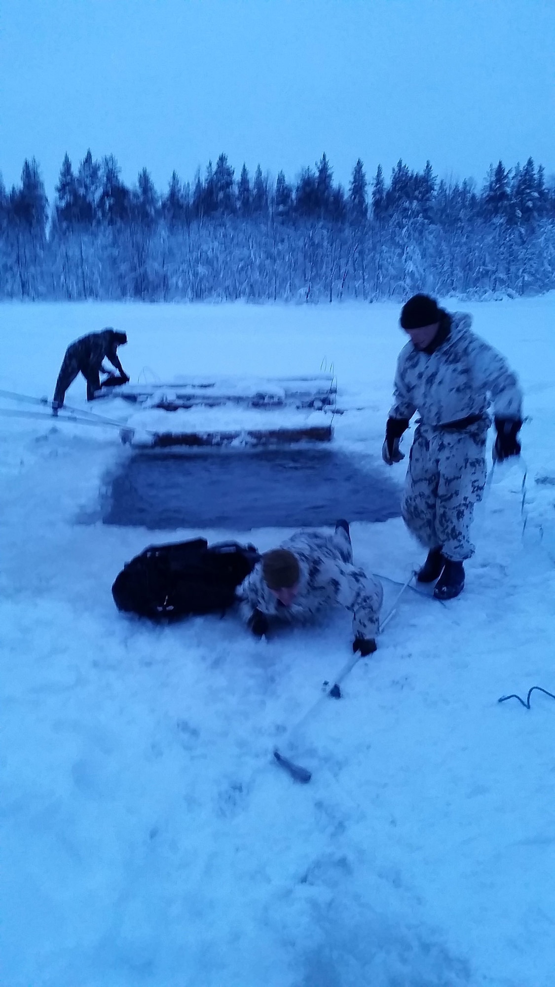 Sgt. 1st Class Cory Birdsong (lower center) with 3rd Battalion (Airborne), 509th Infantry Regiment, 4th Infantry Brigade Combat Team (Airborne), 25th Infantry Division, conducts the breaking through ice drill as part of the Finland Cold Weather Basic Operation Course Jan. 6-16, 2015, to build on relations with the Finland Forces and improve knowledge of operations conducted in a cold weather environment. The 10-day course is similarly structured to the U.S. Army’s Cold Weather Leaders Course, with the exception that the entire course is on skis instead of snow shoes. Some of the basic tasks taught are moving and shooting with skis, building a fire using a survival kit, ski course to learn how to brake going downhill and a ski obstacle course, land navigation with ruck sack and skis, crossing a river with skis and breaking-through-ice drill with skis while wearing a ruck sack. (U.S. Army courtesy photo/Released)