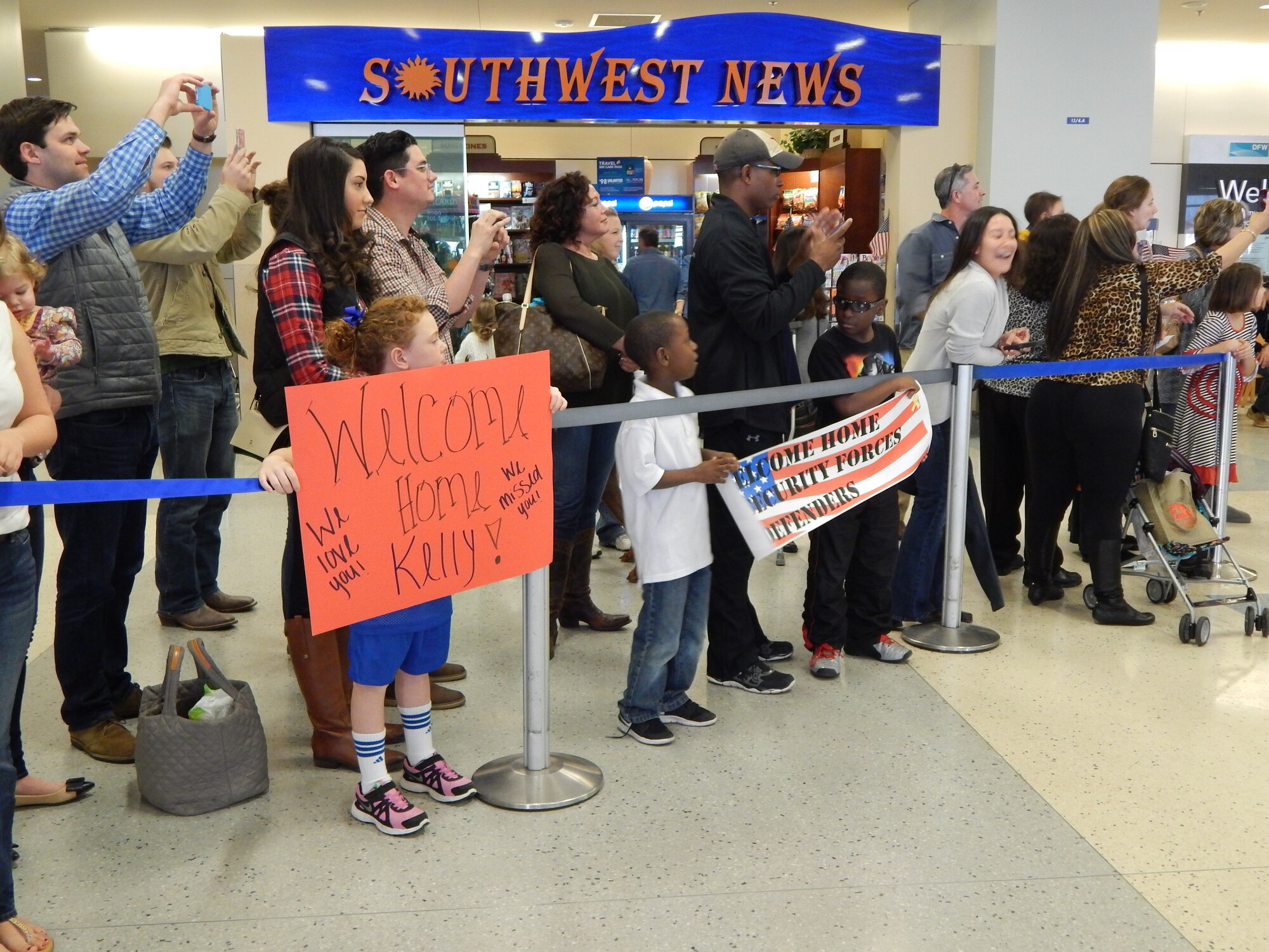 NAVAL AIR STATION FORT WORTH JOINT RESERVE BASE, Texas - On Jan. 24, 2015, family members held banners and waited at Dallas-Fort Worth International Airport to welcome home 14 Airmen from the 301st Security Forces Squadron. The Defenders returned after a six-month deployment to Southwest Asia. (U.S. Air Force photo/Staff Sgt. Malcolm McGuire)