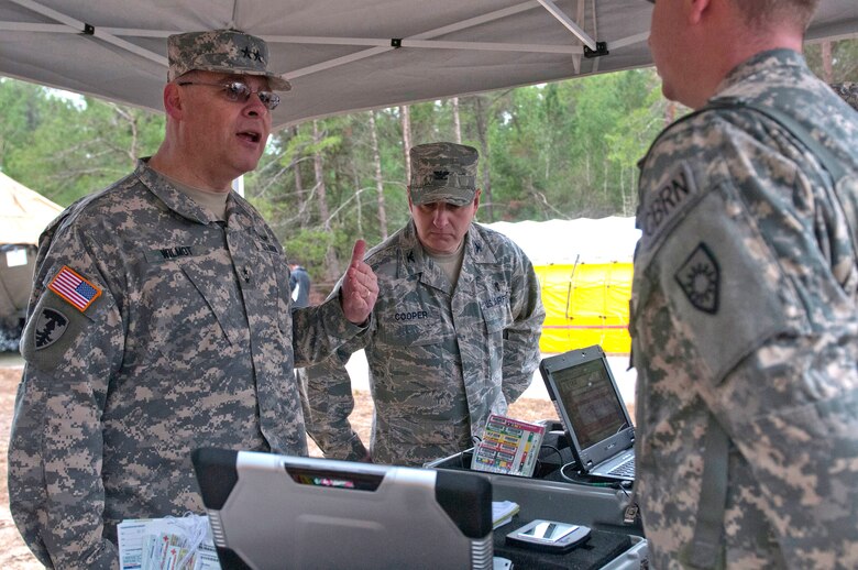 Army Maj. Gen. David E. Wilmot (left), deputy surgeon general for the Army National Guard, discusses the Emergency Tracking and Accountability System that Army Spec. Robert Schwallie (right) of the Kentucky National Guard CERFP is using to track casualties as they move from the hot zone into the cold zone during Operation Starke Thunder at Camp Blanding in Starke, Fla., Jan. 14, 2015. The four-day exercise certified the joint Kentucky Army and Air Guard emergency-response team as mission-ready. (U.S. Air National Guard photo by Staff Sgt. Vicky Spesard)