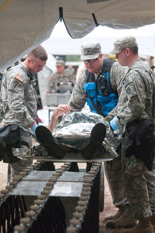 Soldiers from the Kentucky National Guard CERFP move a simulated patient from the hot zone into the cold zone for further triage as part of Operation Starke Thunder at Camp Blanding in Starke, Fla., Jan. 13, 2015. Non-ambulatory patients were moved through decontamination using a gurney placed on rollers. (U.S. Air National Guard photo by Staff Sgt. Vicky Spesard)