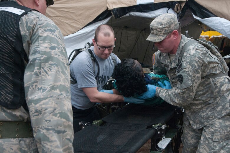 Soldiers from the Kentucky National Guard CERFP move a simulated patient from the hot zone into the cold zone for further triage as part of Operation Starke Thunder at Camp Blanding in Starke, Fla., Jan. 13, 2015. Non-ambulatory patients were moved through decontamination using a gurney placed on rollers. (U.S. Air National Guard photo by Staff Sgt. Vicky Spesard)