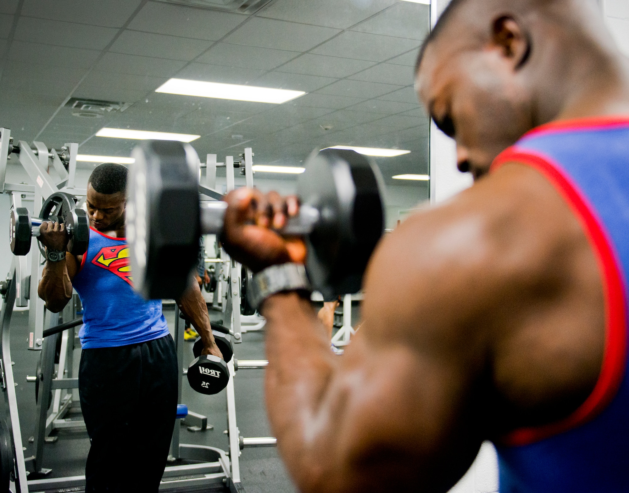 Senior Airman Terrence Ruffin, 16th Electronic Warfare Squadron, lifts 25-pound dumbbells at the fitness center on Eglin Air Force Base, Fla.  In November, the Airman became the youngest professional bodybuilder on the circuit at age 21.  (U.S. Air Force photo/Samuel King Jr.) 