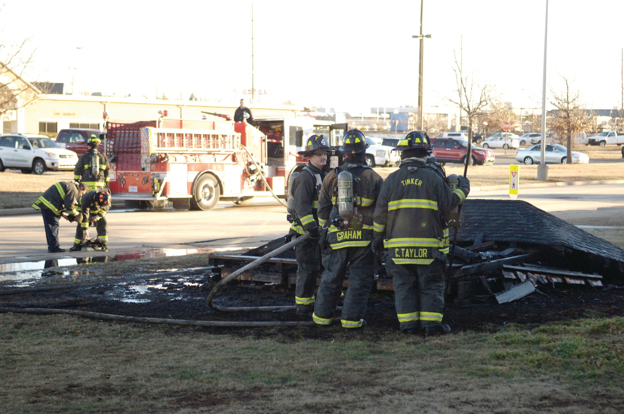 Tinker firefighters stand guard over the smoldering remains of a smoke shack just north of Bldg. 412, south of 5th Street, that burned to the ground within minutes on Monday. Tinker officials remind the workforce to ensure cigarette butts are completely extinguished and to always practice fire awareness, especially with fire danger being extremely high in Oklahoma due to drought conditions. (Air Force photo by Darren D. Heusel)

