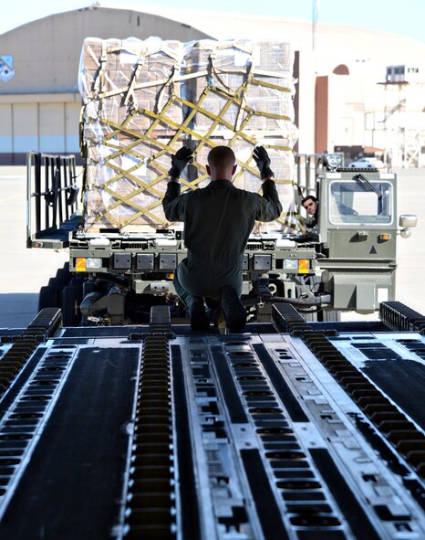 A loadmaster from the 445th Airlift Wing at Wright-Patterson Air Force Base, Ohio, guides a truck carrying cargo onto a C-17 Globemaster III here Jan. 16. The truck was driven by Tech. Sgt. Heston Ashlock, the noncommissioned officer in charge of Terminal Operations in the 72nd Logistics Readiness Squadron. The cargo was flown from Tinker on a humanitarian mission to Haiti. (Air Force photo by Kelly White)