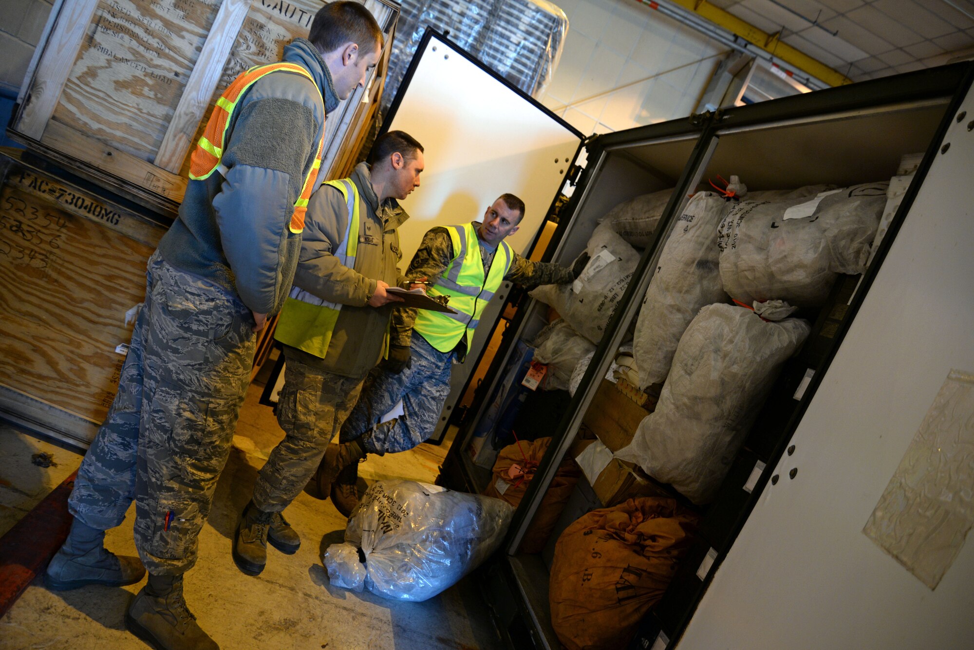 U.S. Air Force Master Sgt. Donley Gower, right, 100th Logistics Readiness Squadron superintendent of small air terminal from Canal Fulton, Ohio, and U.S. Air Force Staff Sgt. Steven Wright, center, 100th LRS NCO in charge of the augmentee program from Belton, S.C., inspect the postal Internal Slingable-Container Unit with U.S. Air Force Airman 1st Class Kyle Hunt, 100th Communications Squadron postal clerk from Mission Viejo, Calif., during a base exercise Jan. 27, 2015, on RAF Mildenhall, England. Both Gower and Wright were looking for things such as undeclared hazardous material, making sure equipment is properly packed and ensuring that there is enough filler material to prevent movement of cargo during transportation. (U.S. Air Force photo by Senior Airman Christine Griffiths/Released)