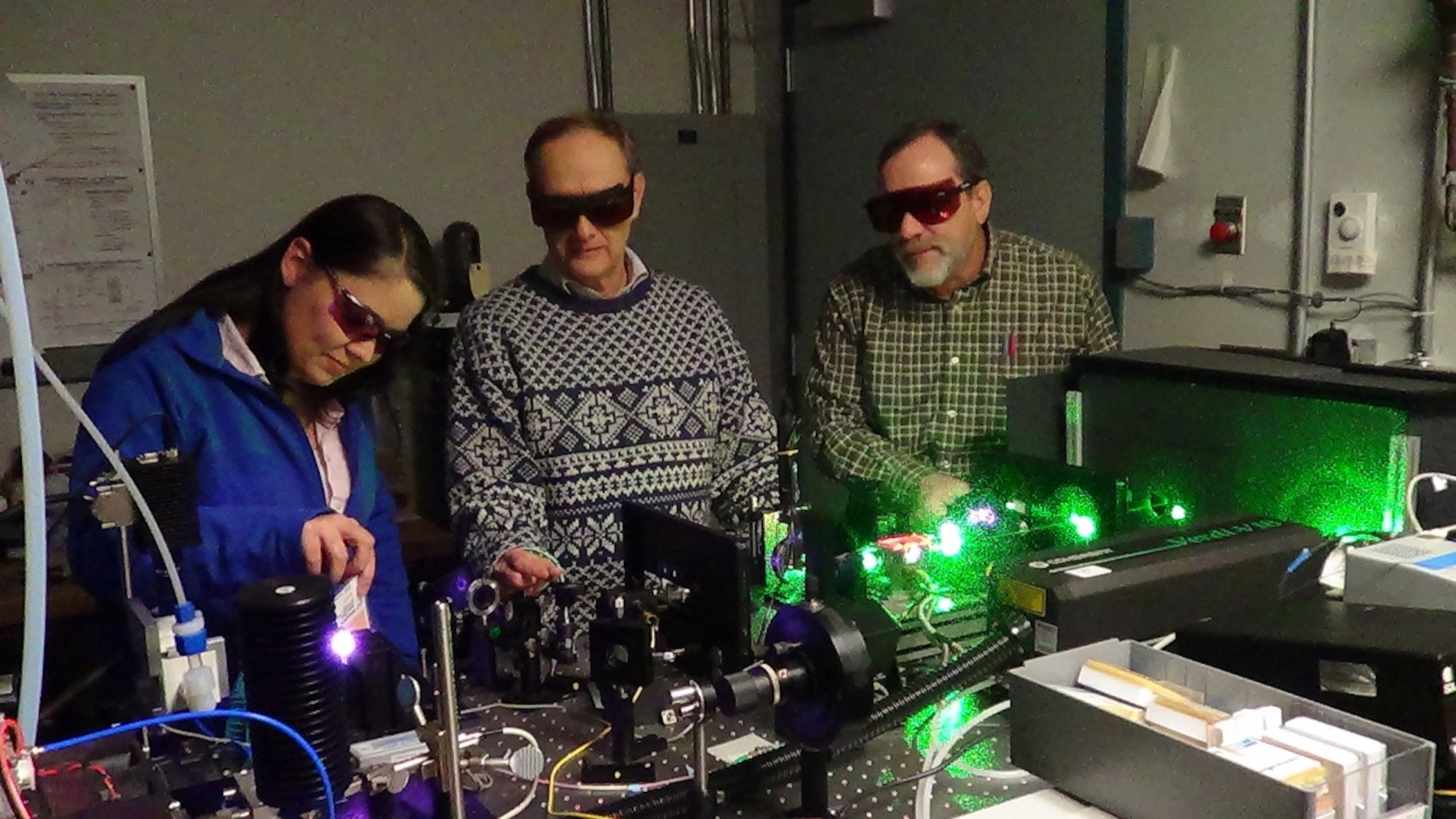 Kristin Galbally-Kinney, Steve Davis, and Terry Rawlins, of Physical Sciences Inc., adjust the excitation source for an argon microplasma laser. (Contributed photo)