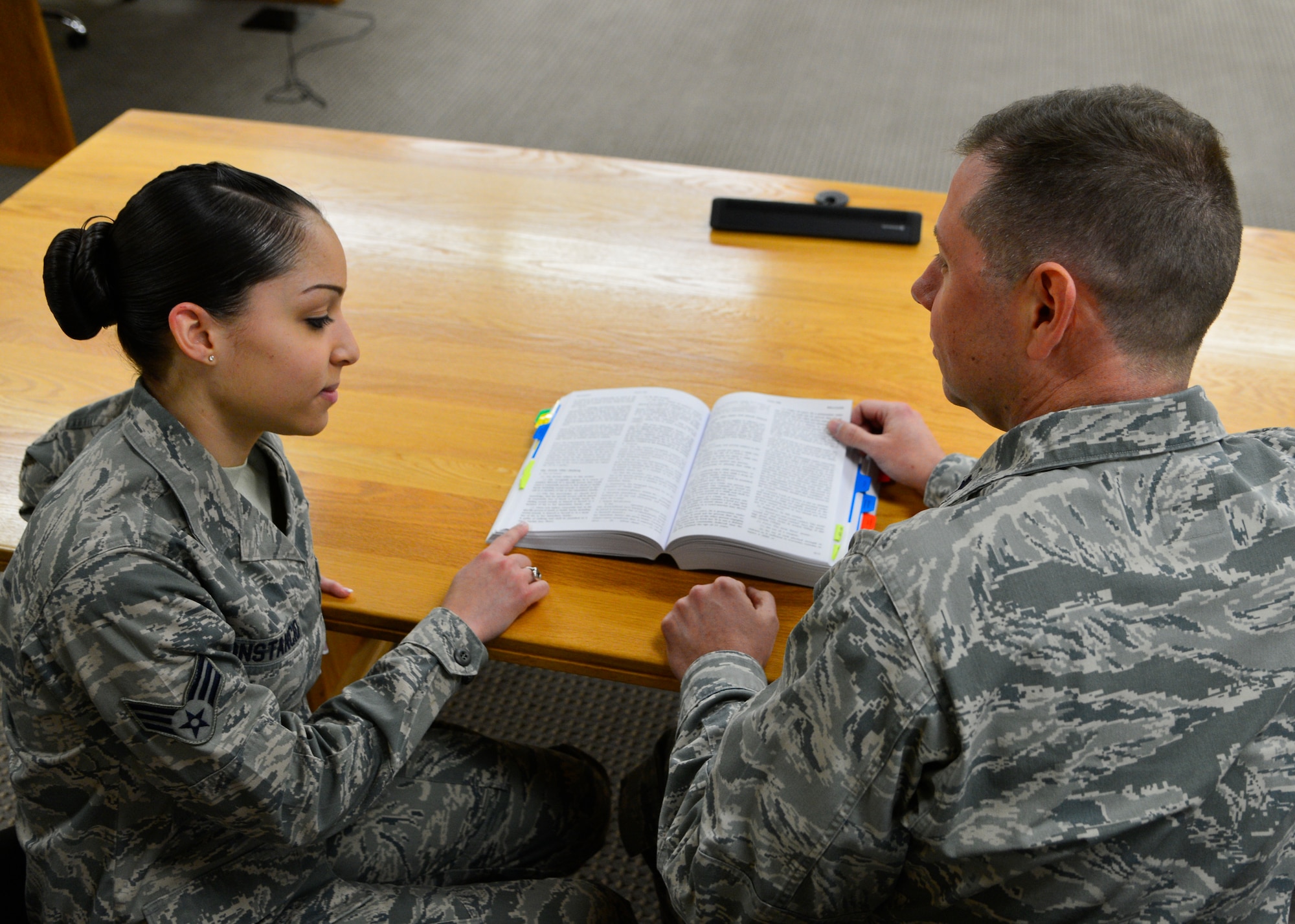 Lt. Col. Scott Boehne, 436th Airlift Wing staff judge advocate, and Senior Airman Savella Constancio, 436th AW general law paralegal, review the Manual for Courts-Martial Jan. 29, 2014, in the courtroom on Dover Air Force Base, Del. The MCM is the official guide to the conduct of courts-martial in the United States military. (U.S. Air Force photo/Airman 1st Class William Johnson)