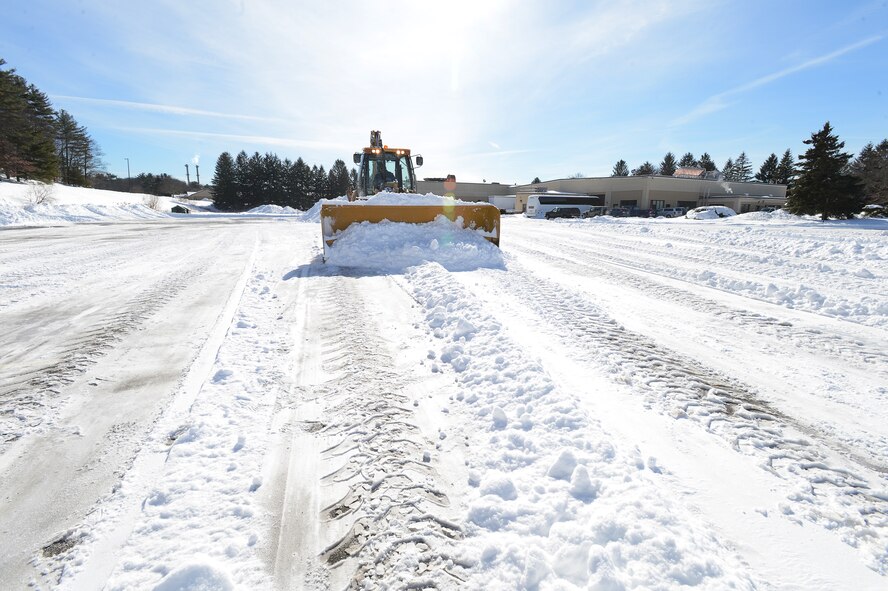 Mike Delancey, Heavy Repair Deputy, Civil Engineering Squadron, 66th Air Base Group, clears a parking lot on base of snow, Jan. 29. Winter Storm Juno dropped several inches of snow on the region. (U.S. Air Force photo by Jerry Saslav)