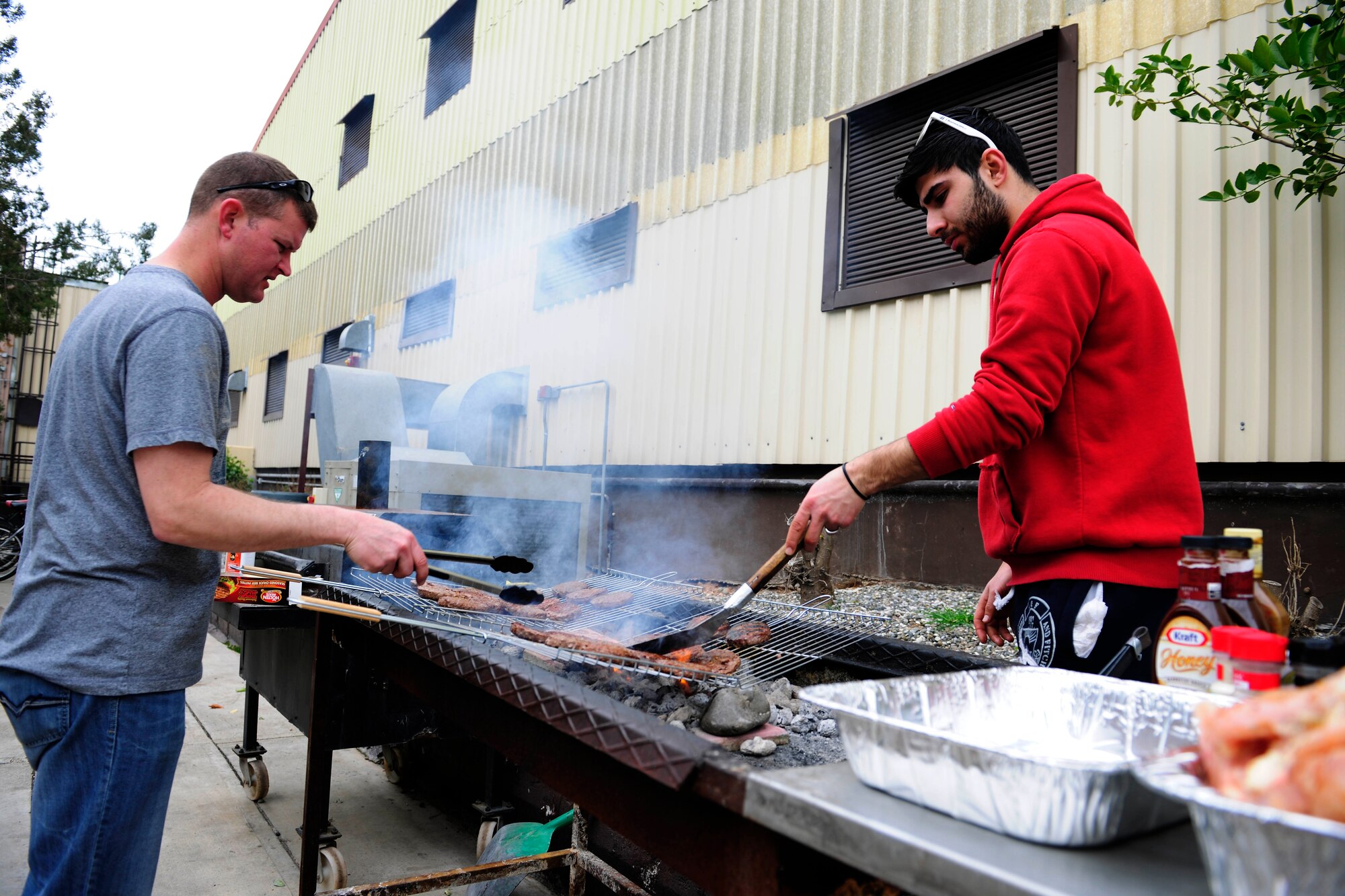Tech. Sgt. Mike Pugh (left), 39th Logistical Readiness Squadron NCO in charge of central storage, and Ayhan Savria, volunteer, prepare food for an International Customs Day luncheon Jan. 26, 2015, at Incirlik Air Base, Turkey. The luncheon was held for Airmen, friends and family of the 39th Air Base Wing and Ministry of Customs and Trade customs agents. (U.S. Air Force photo by Senior Airman Krystal Ardrey/Released)