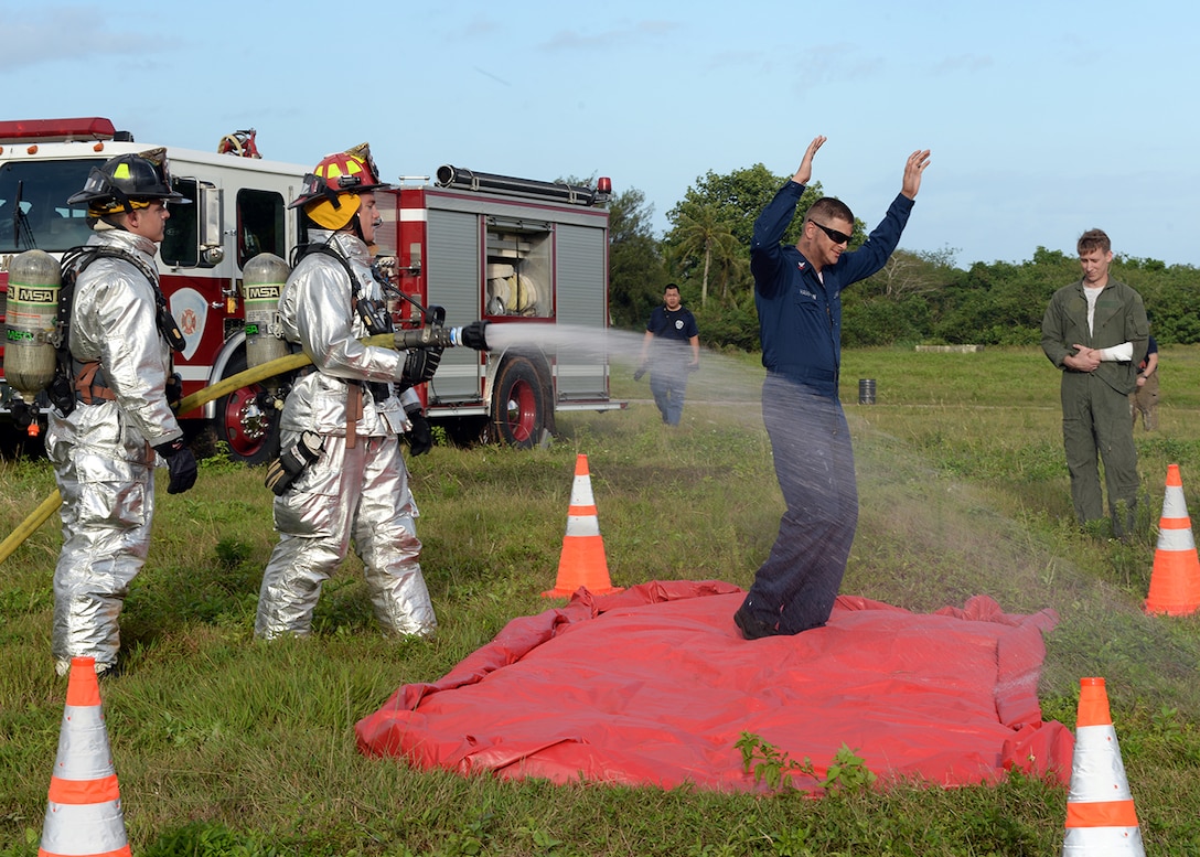 Andersen fire fighters simulate spraying hazardous chemicals off of a role player during a joint emergency management exercise Jan. 27, 2014, at Andersen South, Guam. During the EME, Guam and Andersen first responders were tested on how well they can work together to respond to various emergency scenarios on and off base. (U.S. Air Force photo by Senior Airman Cierra Presentado/Released) 