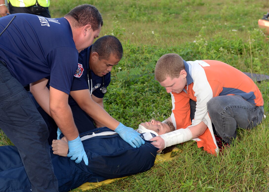 Andersen Airmen and Guam fire department emergency medical technicians stabilize a patient after a simulated helicopter crash during a joint emergency management exercise Jan. 27, 2014, at Andersen South, Guam. The exercise tested the island’s ability to respond to a variety of emergencies and coordinate efforts amongst local and federal response organizations. (U.S. Air Force photo by Senior Airman Cierra Presentado/Released)