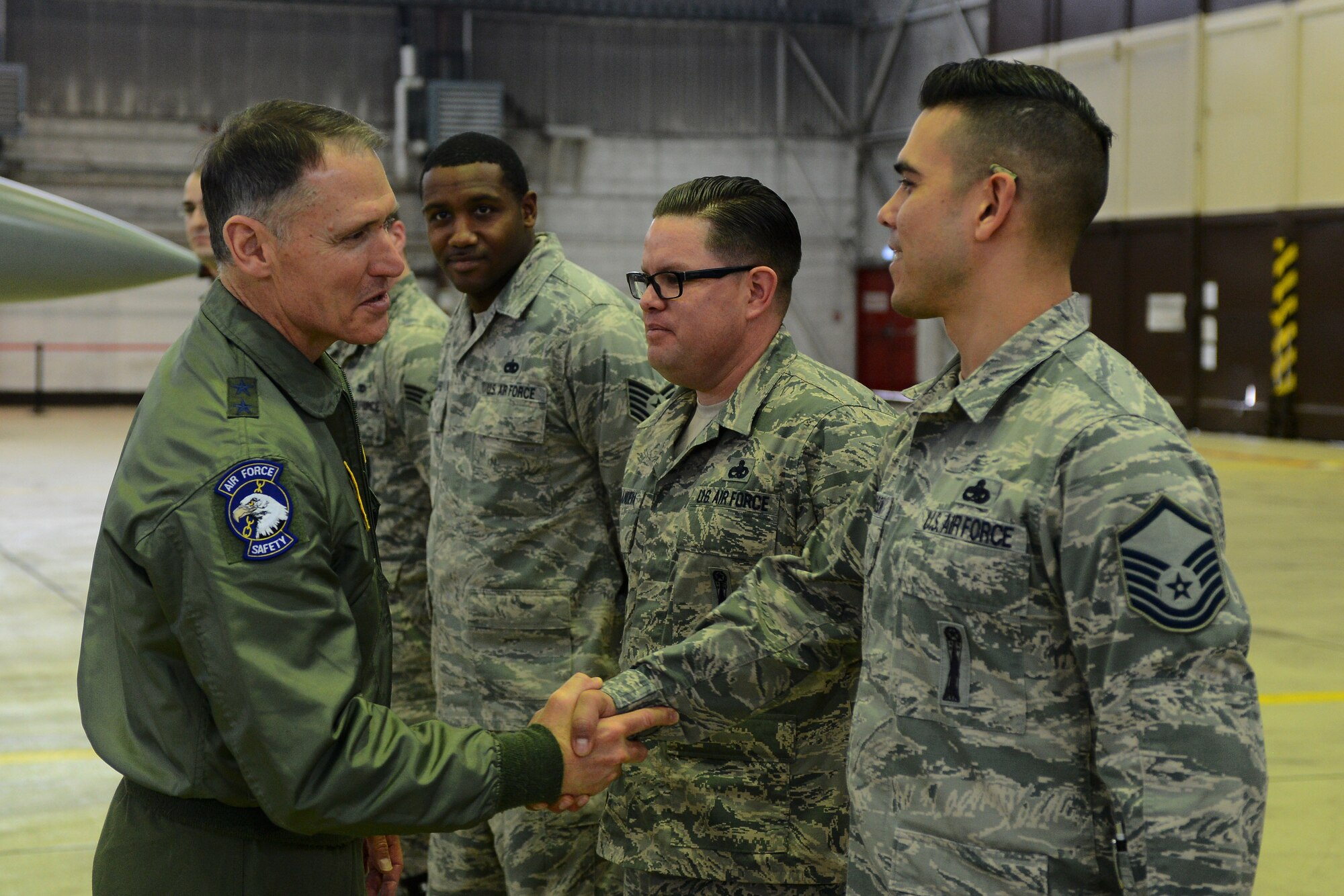 U.S. Air Force Maj. Gen. Kurt Neubauer, Air Force Chief of Safety, shakes hands with U.S. Air Force Master Sgt. Jeff Robinson, 52nd Maintenance Group weapons standardization superintendent, in Hangar 1 at Spangdahlem Air Base, Germany, Jan. 23, 2015. Robinson spoke with Neubauer about the procedures the weapons load team goes through to ensure all safety measures are met. (U.S. Air Force photo by Airman 1st Class Luke Kitterman/Released)