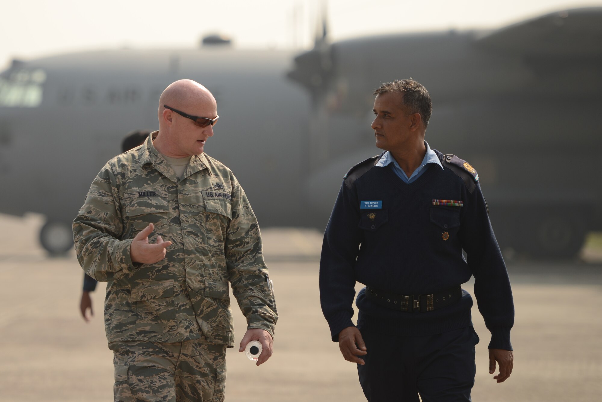U.S. Air Force Senior Master Sgt. Ben Miller talks with Bangladesh Air Force Master Sgt. A. Malek about C-130 aircraft maintenance matters during a subject matter expert exchange at Exercise Cope South, BAF Base Bangabandhu, Jan. 27, 2015. Miller is assigned to the 374th Aircraft Maintenance Squadron, Yokota Air Base, Japan. Cope South is a Pacific Air Forces-sponsored, bilateral tactical airlift exercise conducted in Bangladesh, with a focus on cooperative flight operations, day and night low-level navigation, tactical airdrop, and air-land missions as well as subject-matter expert exchanges in the fields of operations, maintenance and rigging disciplines. (U.S. Air Force photo by 1st Lt. Jake Bailey/Released)