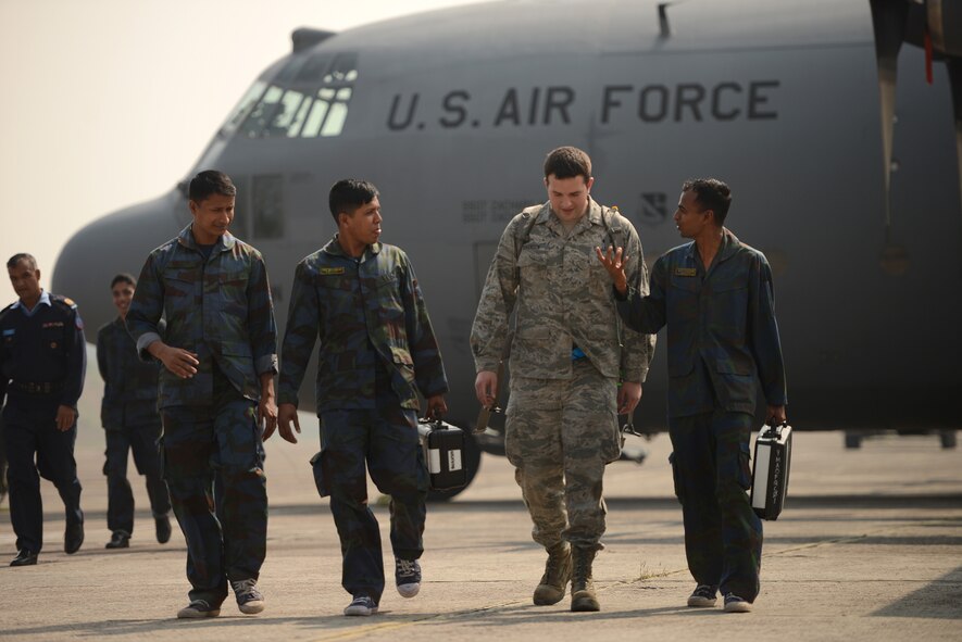 U.S. Air Force Staff Sgt. Scott Sorensen discusses C-130 aircraft maintenance considerations with Bangladesh Air Force maintenance personnel during a subject matter expert exchange at Exercise Cope South, BAF Base Bangabandhu, Jan. 27, 2015. Sorensen is a C-130H guidance and control specialist assigned to the 374th Aircraft Maintenance Squadron, Yokota Air Base, Japan. Cope South is a Pacific Air Forces-sponsored, bilateral tactical airlift exercise conducted in Bangladesh, with a focus on cooperative flight operations, day and night low-level navigation, tactical airdrop, and air-land missions as well as subject-matter expert exchanges in the fields of operations, maintenance and rigging disciplines. (U.S. Air Force photo by 1st Lt. Jake Bailey/Released)