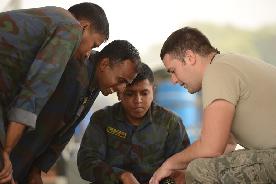 U.S. Air Force Staff Sgt. Scott Sorensen discusses C-130 aircraft control system maintenance considerations with Bangladesh Air Force maintenance personnel during Exercise Cope South at BAF Base Bangabandhu, Jan. 27, 2015. Sorensen is a C-130H guidance and control specialist assigned to the 374th Aircraft Maintenance Squadron, Yokota Air Base, Japan. Cope South is a Pacific Air Forces-sponsored, bilateral tactical airlift exercise conducted in Bangladesh, with a focus on cooperative flight operations, day and night low-level navigation, tactical airdrop, and air-land missions as well as subject-matter expert exchanges in the fields of operations, maintenance and rigging disciplines. (U.S. Air Force photo by 1st Lt. Jake Bailey/Released)