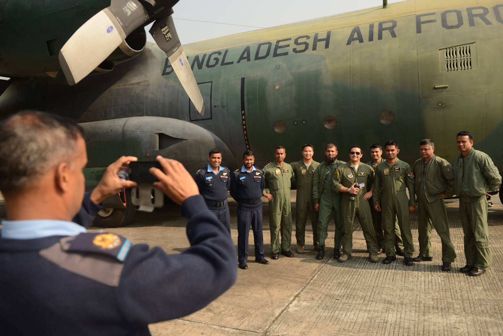 U.S. Air Force and Bangladesh Air Force personnel take a group photo in front of a BAF C-130B aircraft during Exercise Cope South at BAF Base Bangabandhu, Jan. 27, 2015. Cope South is a Pacific Air Forces-sponsored, bilateral tactical airlift exercise conducted in Bangladesh, with a focus on cooperative flight operations, day and night low-level navigation, tactical airdrop, and air-land missions as well as subject-matter expert exchanges in the fields of operations, maintenance and rigging disciplines. Cope South helps cultivate common bonds, foster good will, and improve readiness and compatibility between members of the Bangladesh and U.S. Air Forces. (U.S. Air Force photo by 1st Lt. Jake Bailey/Released)