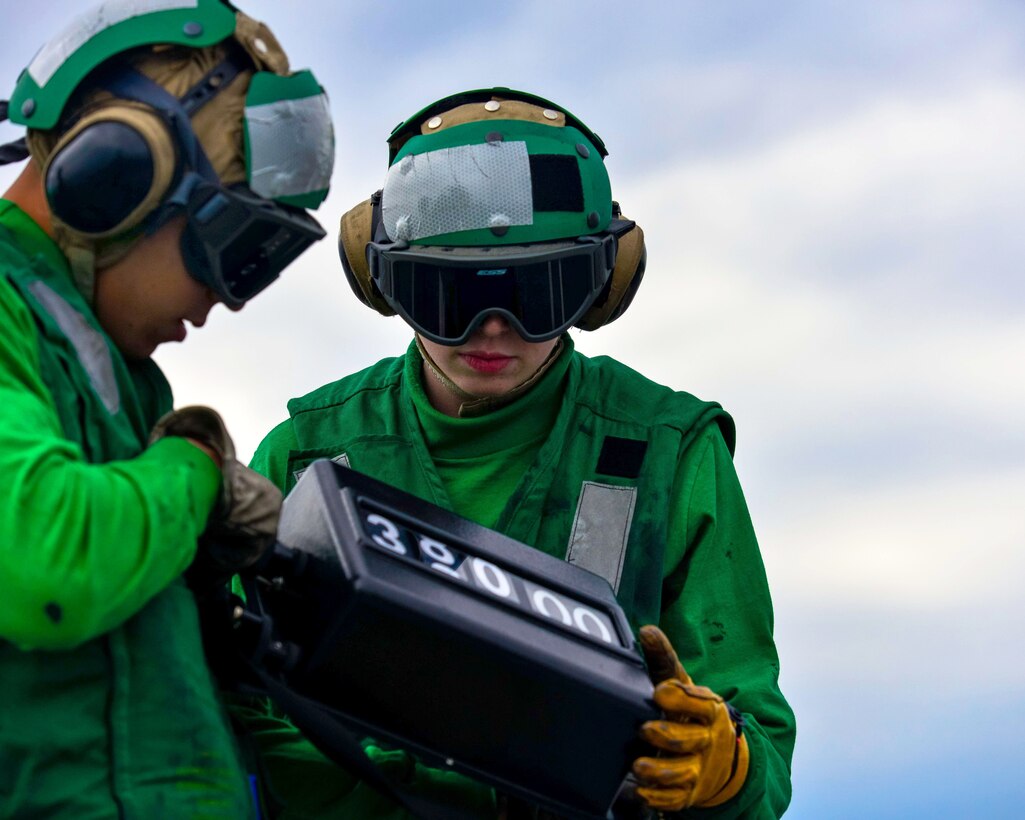 U.S. Navy Seaman Israel Pedraza and Seaman Megan Miller change a weight board on the flight deck of the aircraft carrier USS John C. Stennis in the Pacific Ocean, Jan. 26, 2015. Pedraza is an airman and Miller is an aviation boatswain's mate equipment.