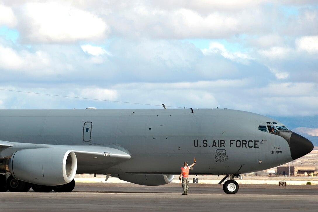 A U.S. Air Force airman marshals a KC-135 Stratotanker aircraft on the ...