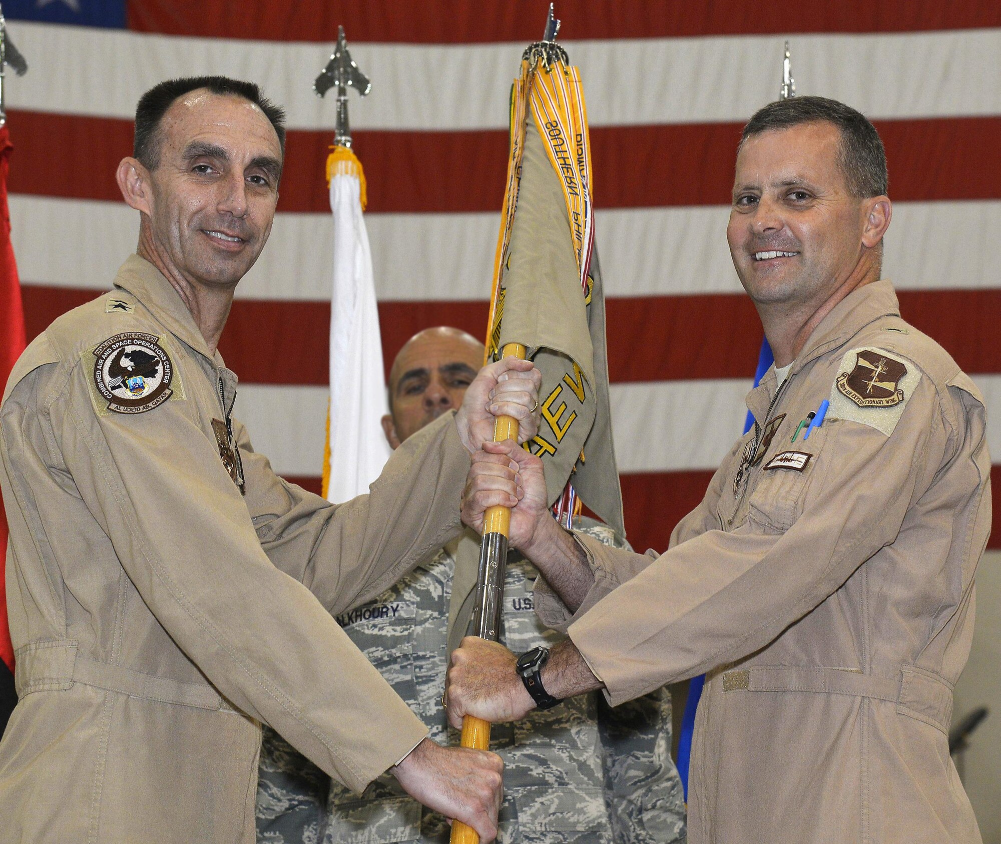 Maj. General Scott Zobrist, left, passes the 380th Air Expeditionary Wing guidon to Brig. Gen. Daniel Orcutt, right, during the wing change of command ceremony June 30, 2015. Orcutt, Commander of the 380th AEW, is a command pilot with over 4,000 hours. Zobrist is the Deputy Commander of U.S. Air Forces Central Command, and Deputy, Combined Forces Air Component Commander. (U.S. Air Force photo/Tech. Sgt. Christopher Boitz)