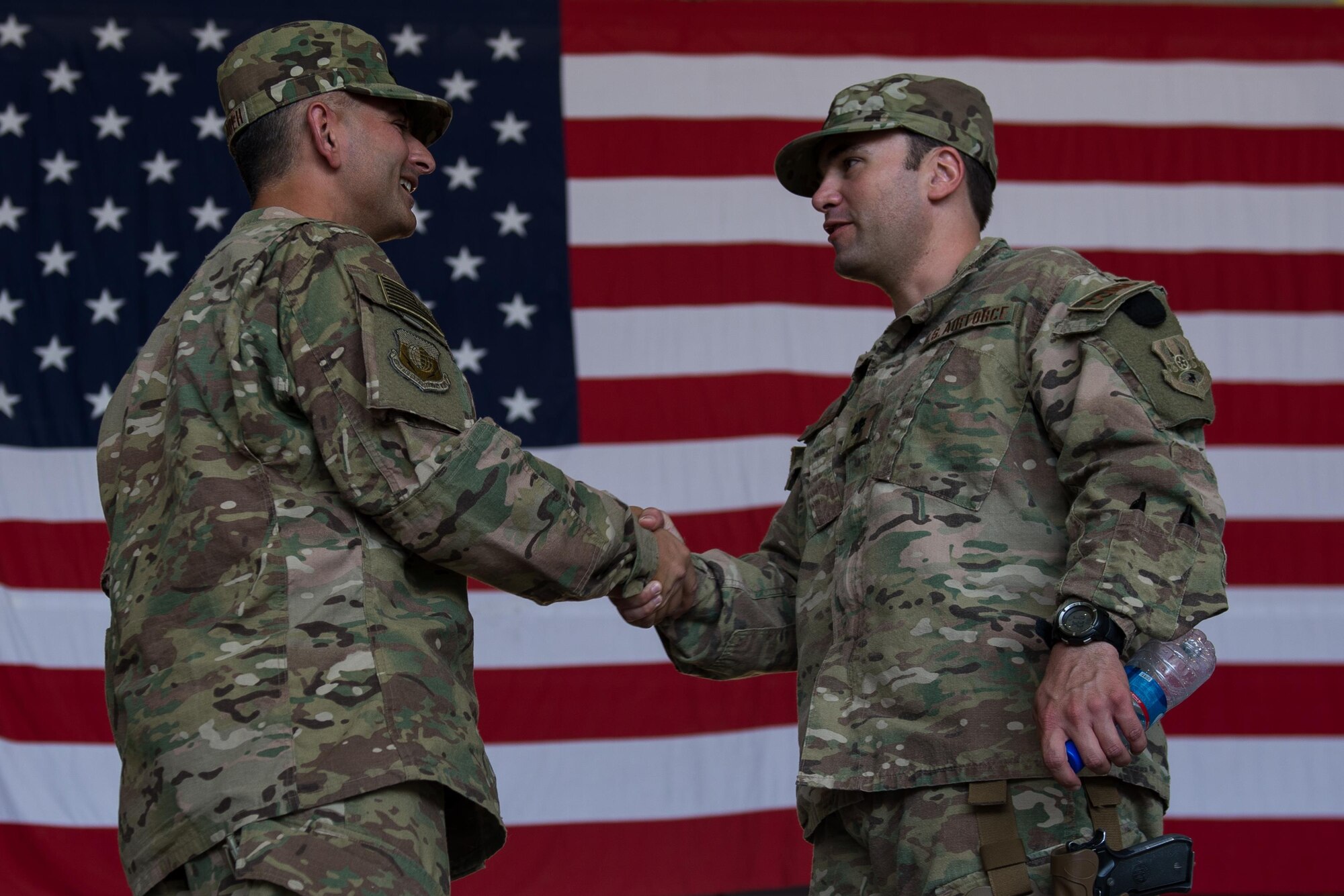 U.S. Air Force Brig. Gen. Dave Julazadeh, 455th Air Expeditionary Wing commander, shakes hands with Lt. Col. Heath Frye, 455th Expeditionary Communications Squadron commander, after the 455th AEW change of command ceremony July 1, 2015, at Bagram Airfield, Afghanistan. During the ceremony Julazadeh took over command of the 455th AEW from Brig. Gen. Mark Kelly.  (U.S. Air Force photo by Tech. Sgt. Joseph Swafford/Released)