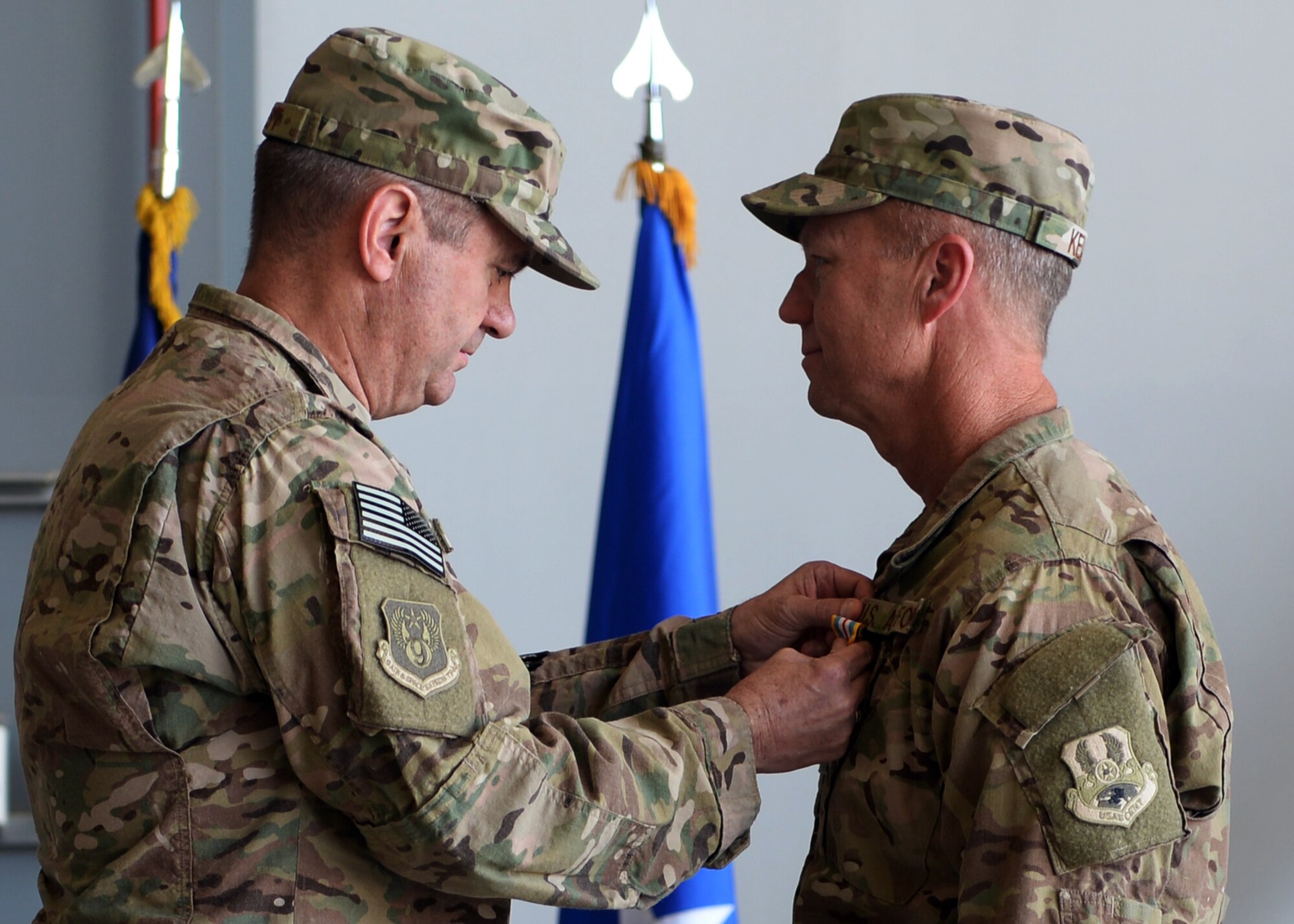 U.S. Air Force Maj. Gen. Scott West, 9th Air and Space Expeditionary Task Force-Afghanistan commander, pins a defense superior service medal on Brig. Gen. Mark Kelly, now former 455th Air Expeditionary Wing commander, during a change of command ceremony July 1, 2015 at Bagram, Airfield, Afghanistan. Kelly relinquished command to Brig. Gen. Dave Julazadeh. (U.S. Air Force photo by Senior Airman Cierra Presentado/Released)