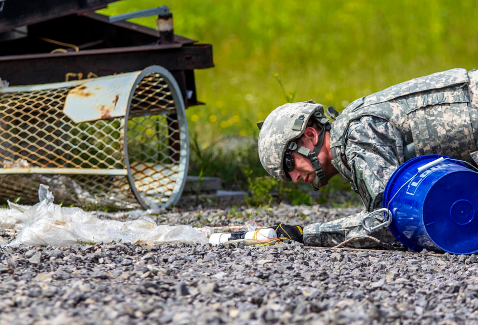 A New York Army National Guard Soldier of the 1108th Explosive Ordnance Disposal (EOD) Company, New York Army National Guard, examines a training IED during the Raven's Challenge bomb disposal training exercise on June 25, 2015, at the New York State Preparedness Training Center in Oriskany, N.Y.

