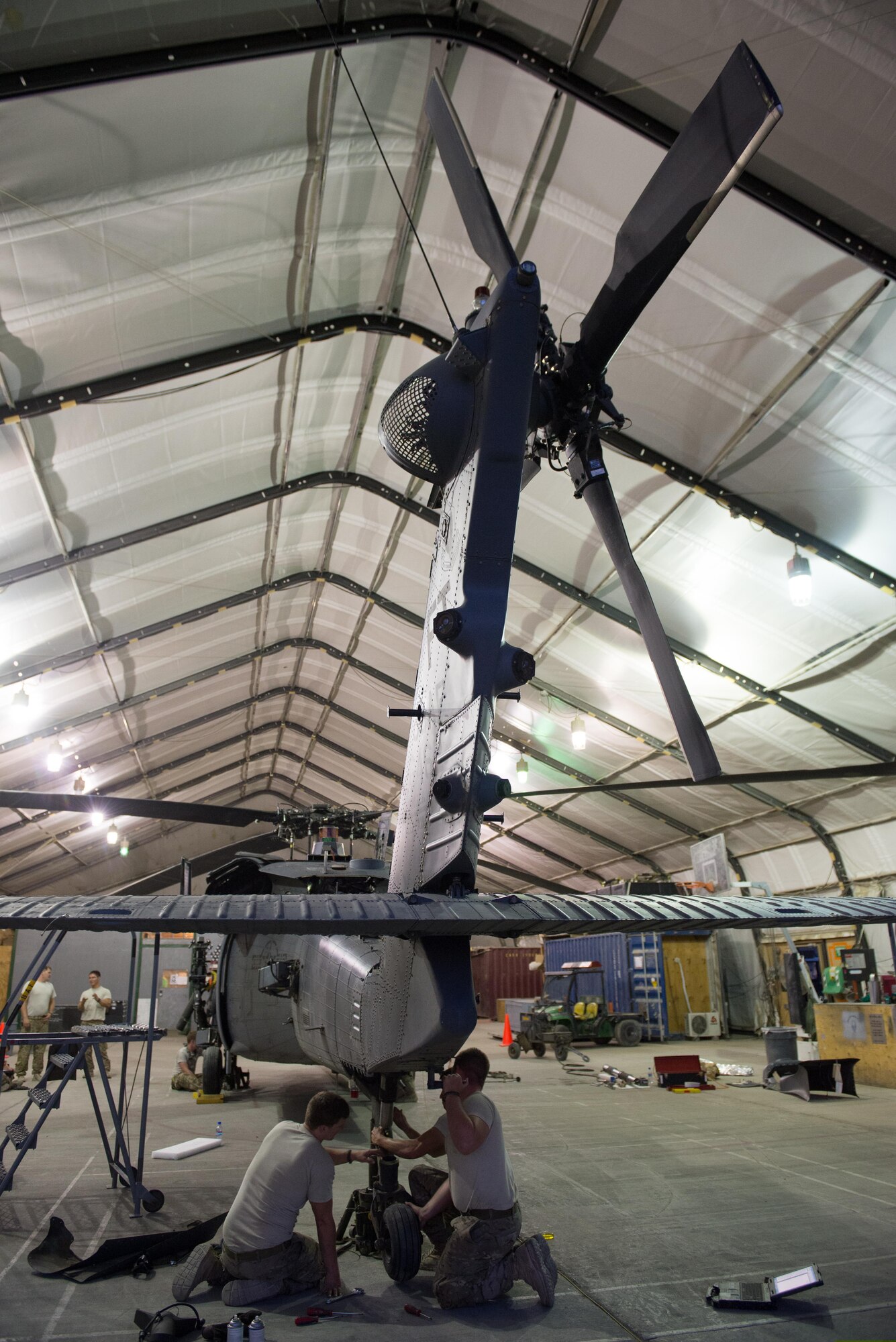 U.S. Airmen assigned to the 455th Expeditionary Aircraft Maintenance Squadron work to complete a 50 hour inspection on a HH-60 Pave Hawk helicopter at Bagram Airfield, Afghanistan, June 28, 2015. The 455th EAMXS ensure Pave Hawks on Bagram are prepared for flight and return them to a mission-ready state once they land. (U.S. Air Force photo by Tech. Sgt. Joseph Swafford/Released)