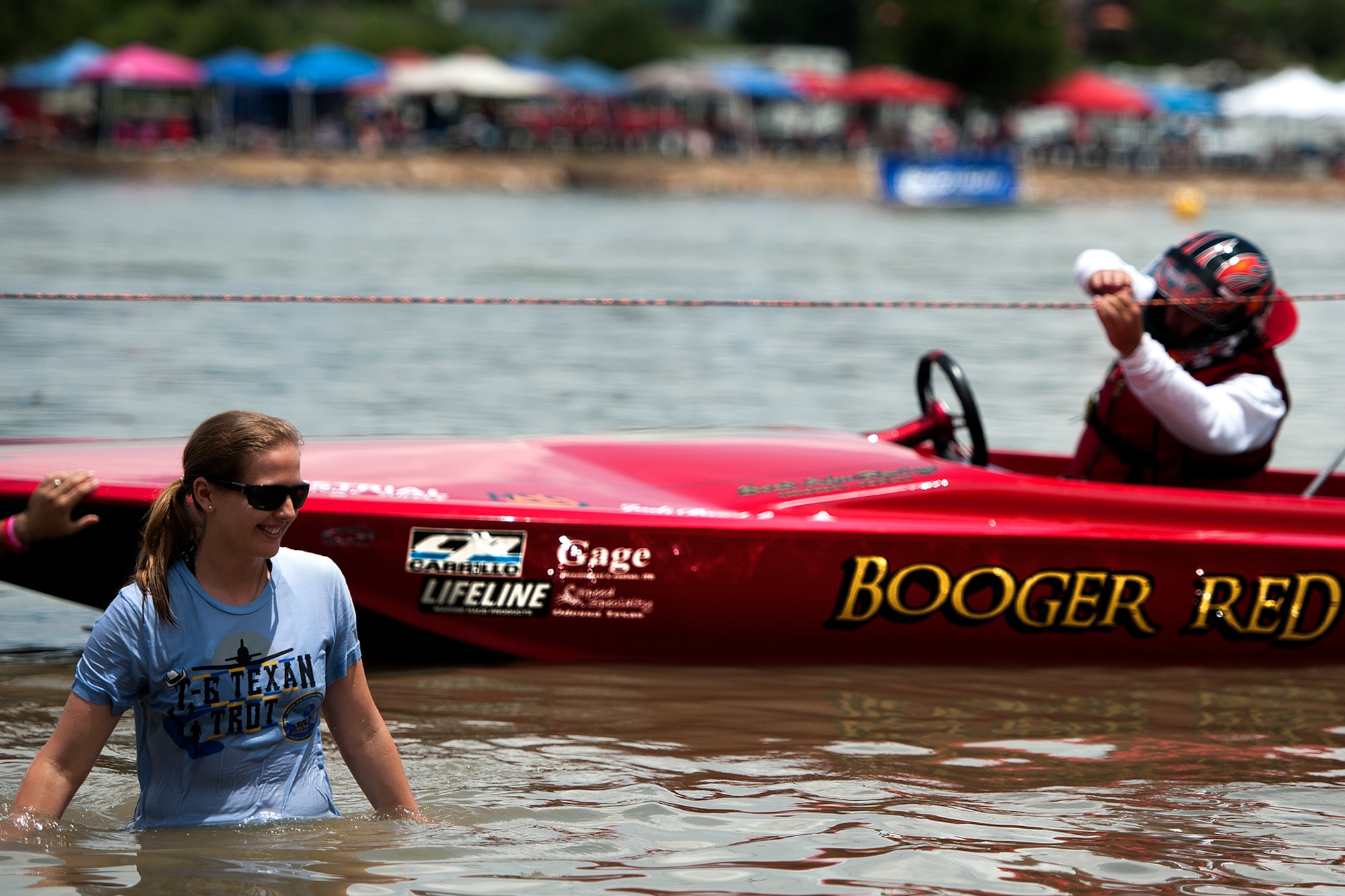 U.S. Air Force 1st Lt. Chelsea M. Connolly, Goodfellow Air Force Base 315th Training Squadron student, stands waist deep in Lake Nasworthy during the 2015 showdown in San Angelo Super Nationals drag boat races in San Angelo, Texas, June 27. Connolly said it was nice to give back to the community by volunteering to help out with the boat races. (U.S. Air Force photo by Airman 1st Class Devin Boyer/Released)