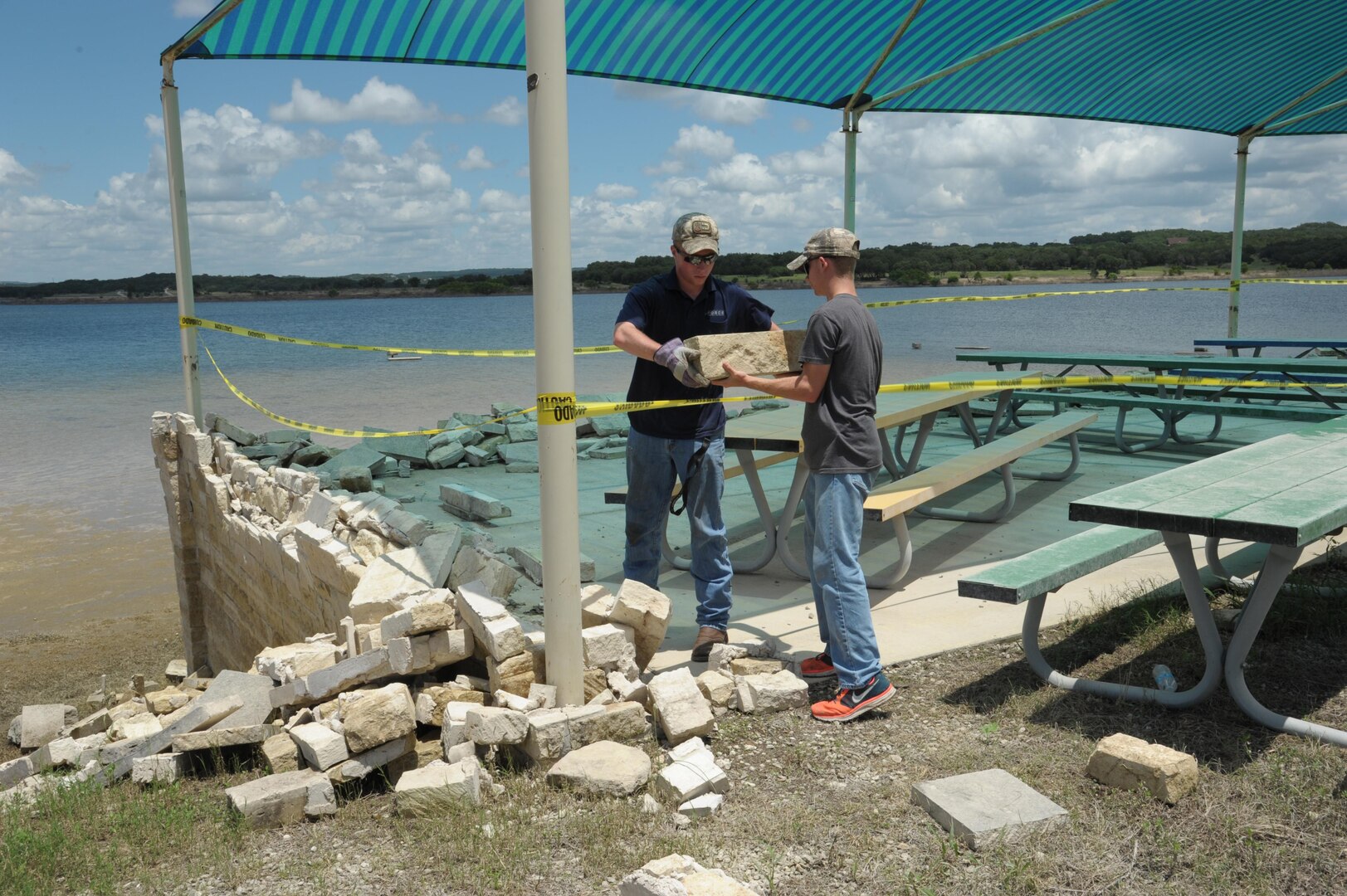 Dillon Tyson (left) and Thomas Bonecutter, 502nd Force Support Squadron recreational aides, clean up debris from the heavy rains and flooding June 24 at the Joint Base San Antonio Canyon Lake Recreation Park. Lake accommodations are open to all Department of Defense cardholders and include cabins, shelters,  tent campsites.  In addition to campsites and nature trails, the park features recreational vehicle sites with boat, canoe hook ups, kayak rentals, two fishing piers, soccer fields, beach volleyball courts, boat ramps and waterfront access to Canyon Lake. (U.S. Air Force photo by Joel Martinez) 