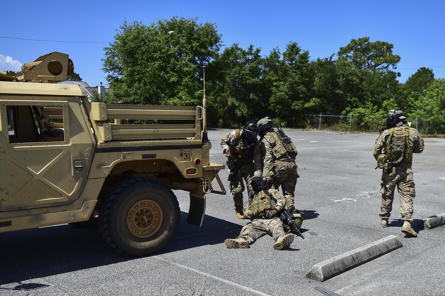 Deployed Aircraft Ground Response Element Airmen move their injured team member Airman 1st Class Joshua Belton, 1st Special Operations Security Forces Squadron DAGRE, to a safe location after a simulated injury during a field training exercise in Fort Walton Beach, Fla., June 19, 2015. The FTX simulated the DAGRE team escorting a finance specialist to make a transfer of funds. (U.S. Air Force photo/Senior Airman Jeff Parkinson) (U.S. Air Force photo/Senior Airman Jeff Parkinson)