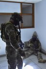 Airman 1st Class Joshua Belton, 1st Special Operations Security Forces Squadron Deployed Aircraft Ground Response Element, stands over a simulated enemy combatant after completing close-quarters combat training in Fort Walton Beach, Fla., June 19, 2015. The FTX simulated the DAGRE team escorting a finance specialist to make a transfer of funds. (U.S. Air Force photo/Senior Airman Jeff Parkinson)