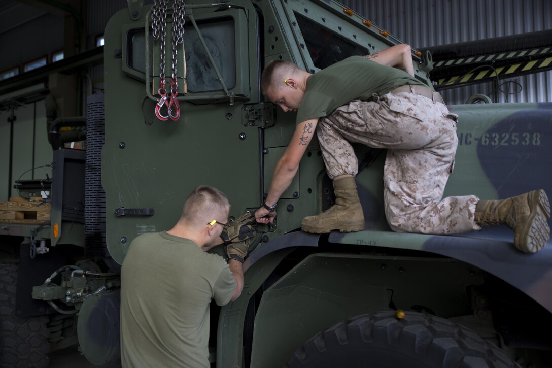 Lance Cpl. Kevin Gaber (left) and Lance Cpl. Jason Bark (right), automotive organizational mechanics for Combat Logistics Battalion 451, Combat Logistics Regiment 45, 4th Marine Logistics Group, Marine Forces Reserve, install the doors onto a cargo truck in Trondheim, Norway, June 24, 2015 during the Personnel Temporary Augmentee Program Norway 2015. For the past 10 years, a task-organized detachment from 4th MLG has deployed to Norway to augment the Norwegian Defense Logistics Organization in order to repair and restore equipment used to support future contingency operations. By maintaining strategic locations throughout Norway, the program promotes regional security, maintains national interoperability and supports rapid response to crises and contingencies throughout the continents of Europe and Africa.
