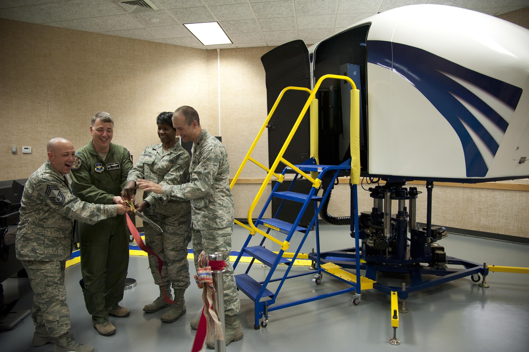From the left, Chief Master Sgt. Joseph Powell, the 71st Medical Group superintendent, Col. John Cinnamon, the 71st Operations Group commander, Col. Kirsten Benford, the 71st MDG commander, and Lt. Col. Daniel Loveless, the 71st Medical Operations Squadron commander, cut the ribbon for the Spatial Disorientation Trainer during a ceremony July 1 at Vance Air Force Base, Oklahoma. (U.S. Air Force photo by Staff Sgt. Nancy Falcon) 